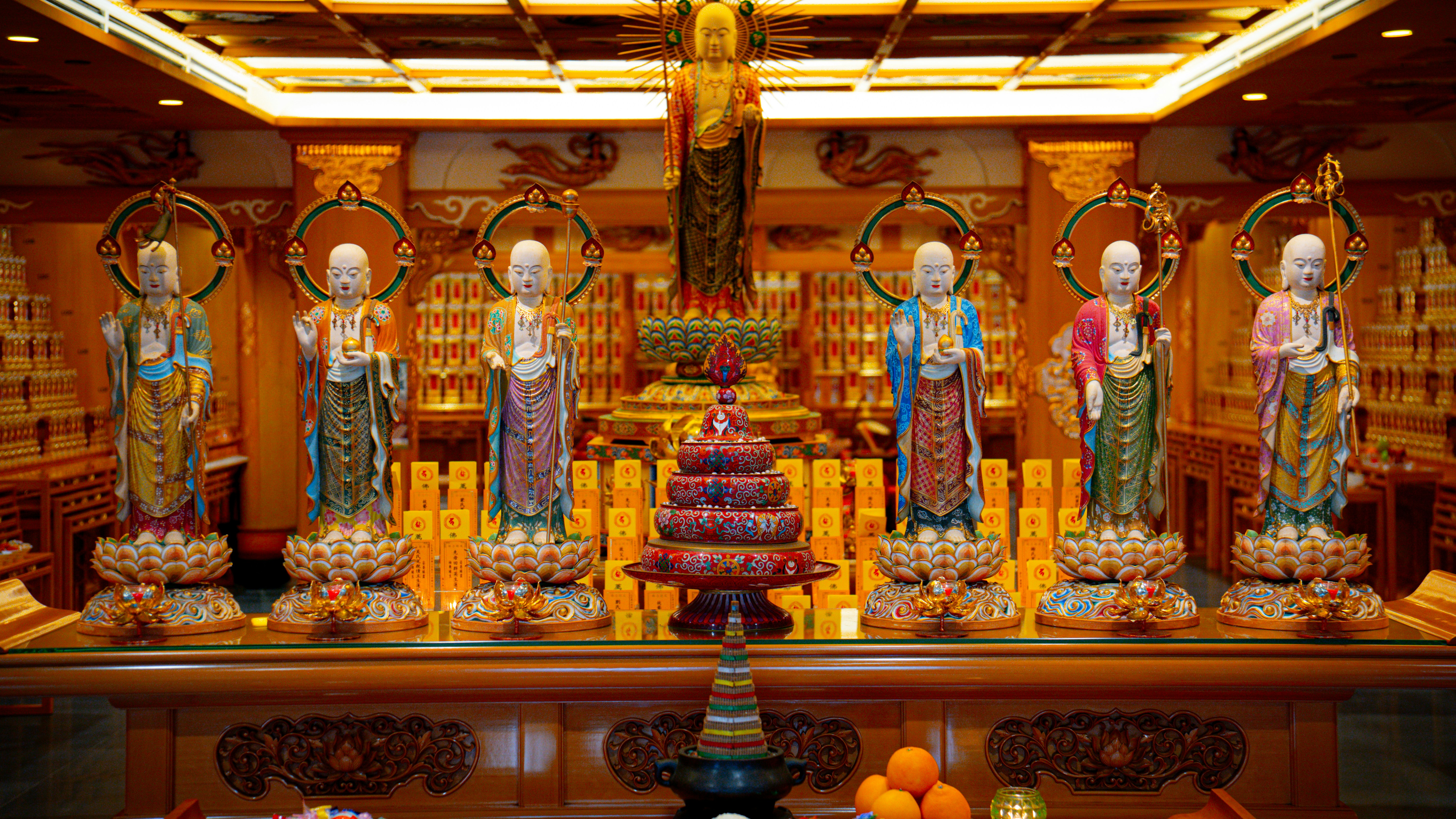 Multiple colorful buddha statues arranged in a traditional temple.