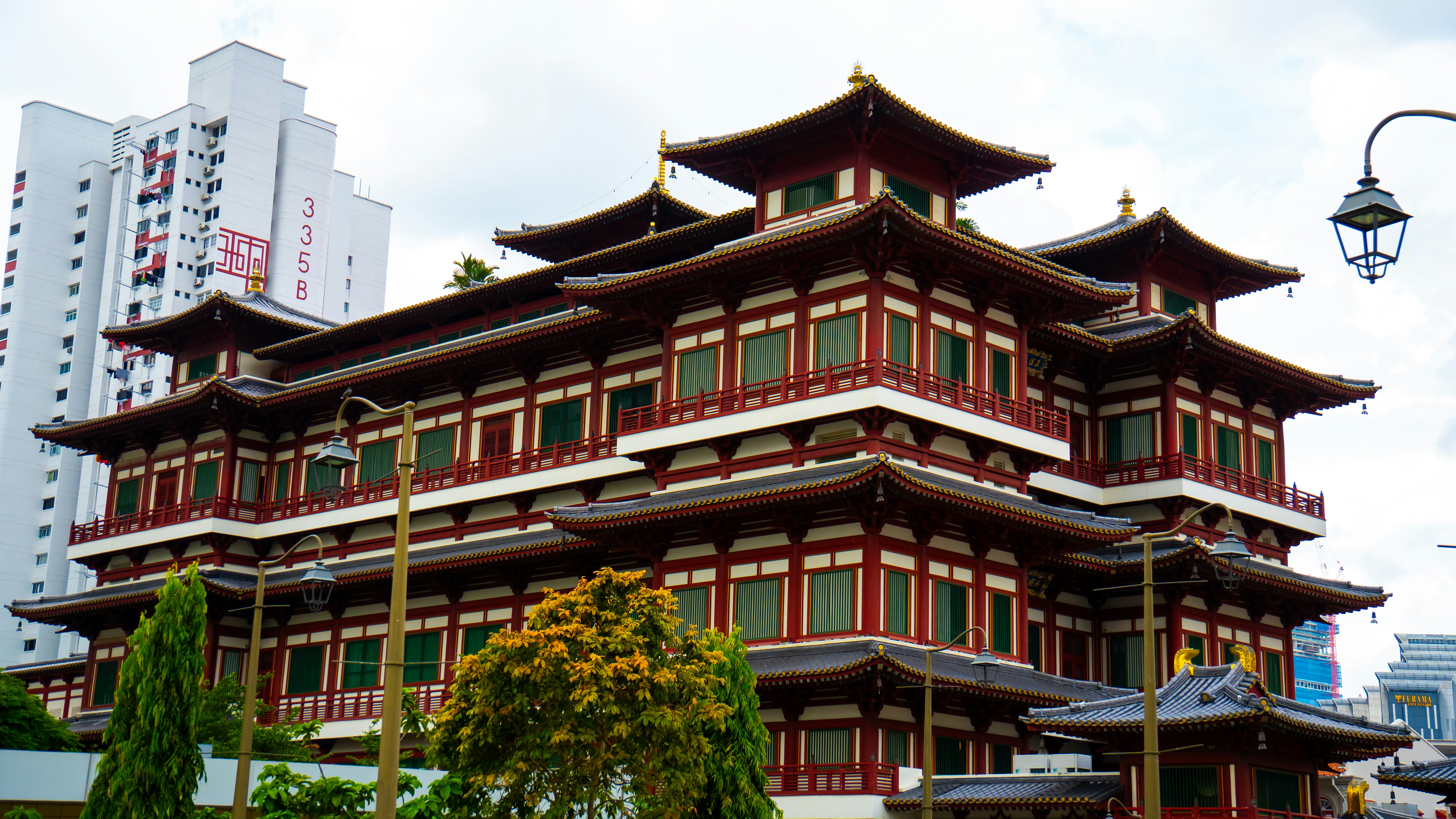 Traditional multi-tiered asian temple stands against a modern city backdrop