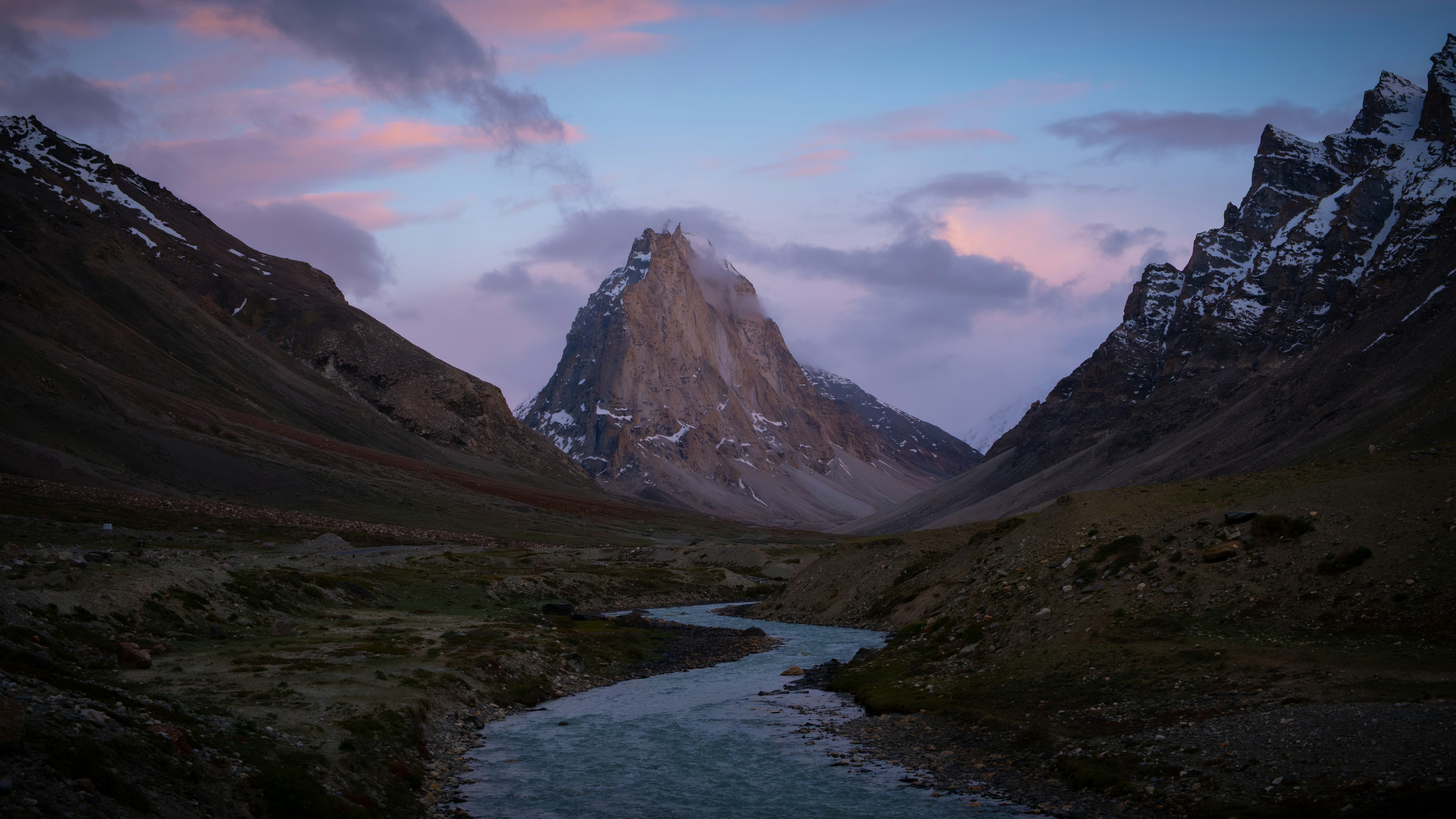 River flows through a mountain valley at colorful dawn