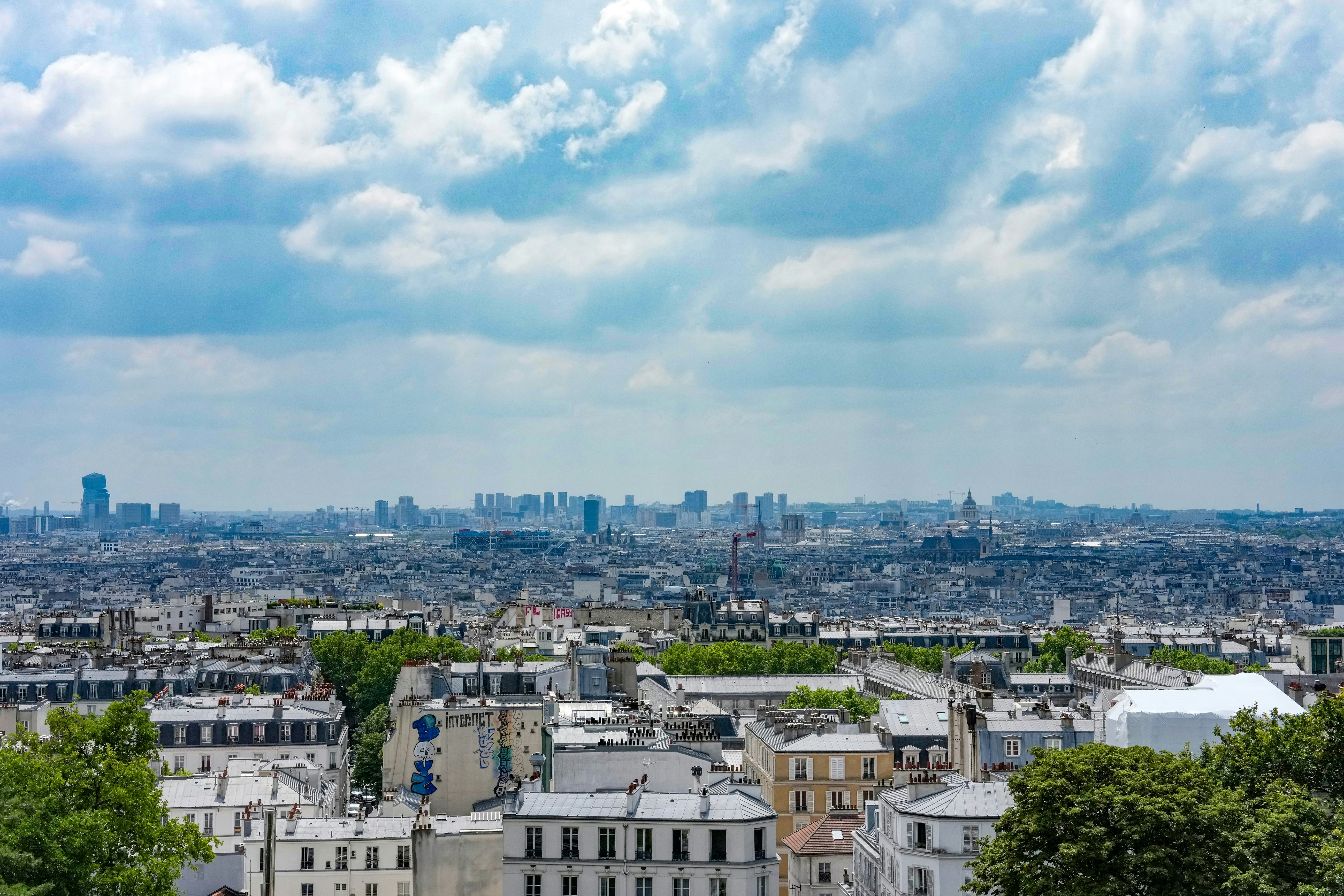 A vast cityscape under a cloudy sky with distant skyscrapers.
