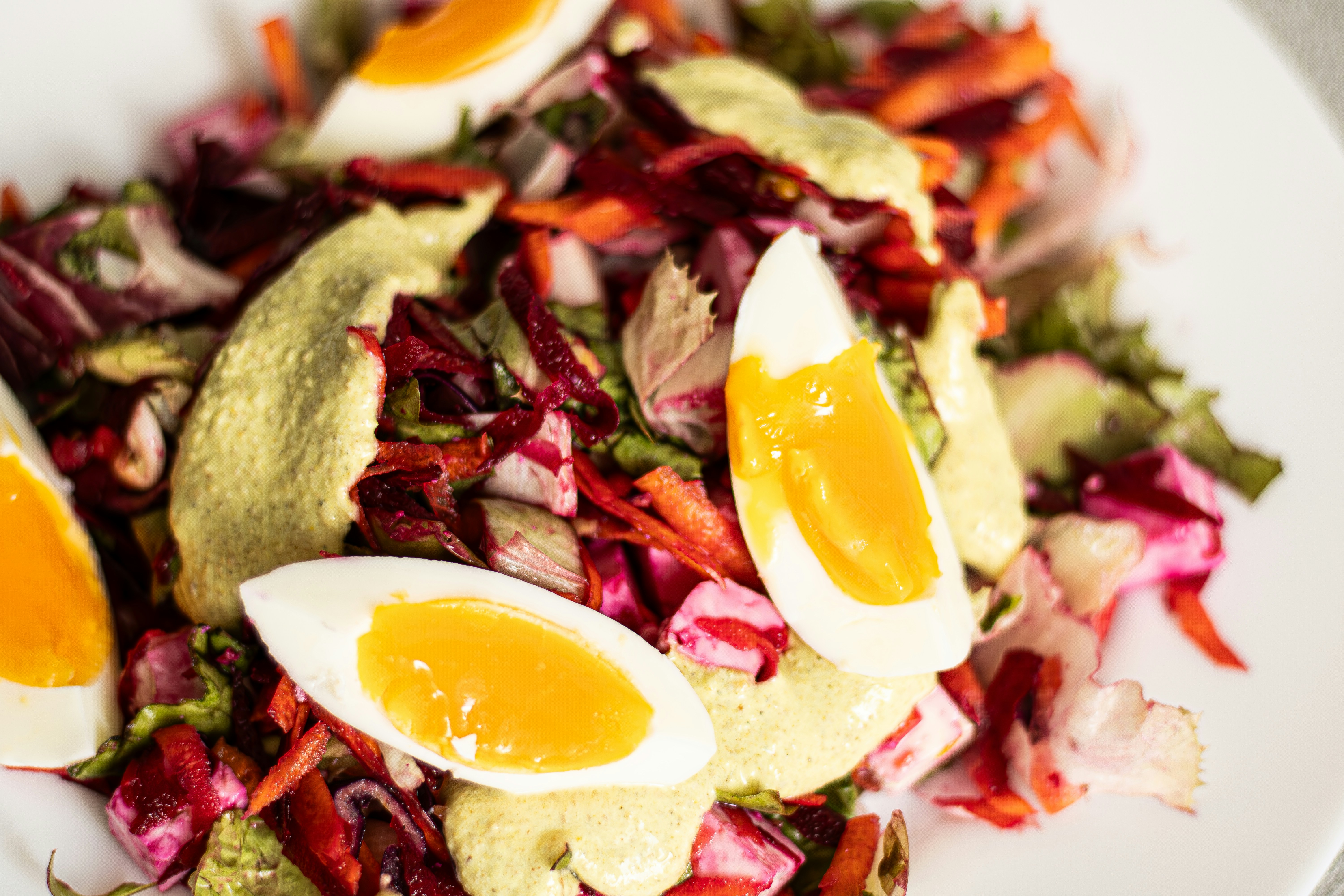 Salad warna-warni dengan telur rebus dan saus krim.