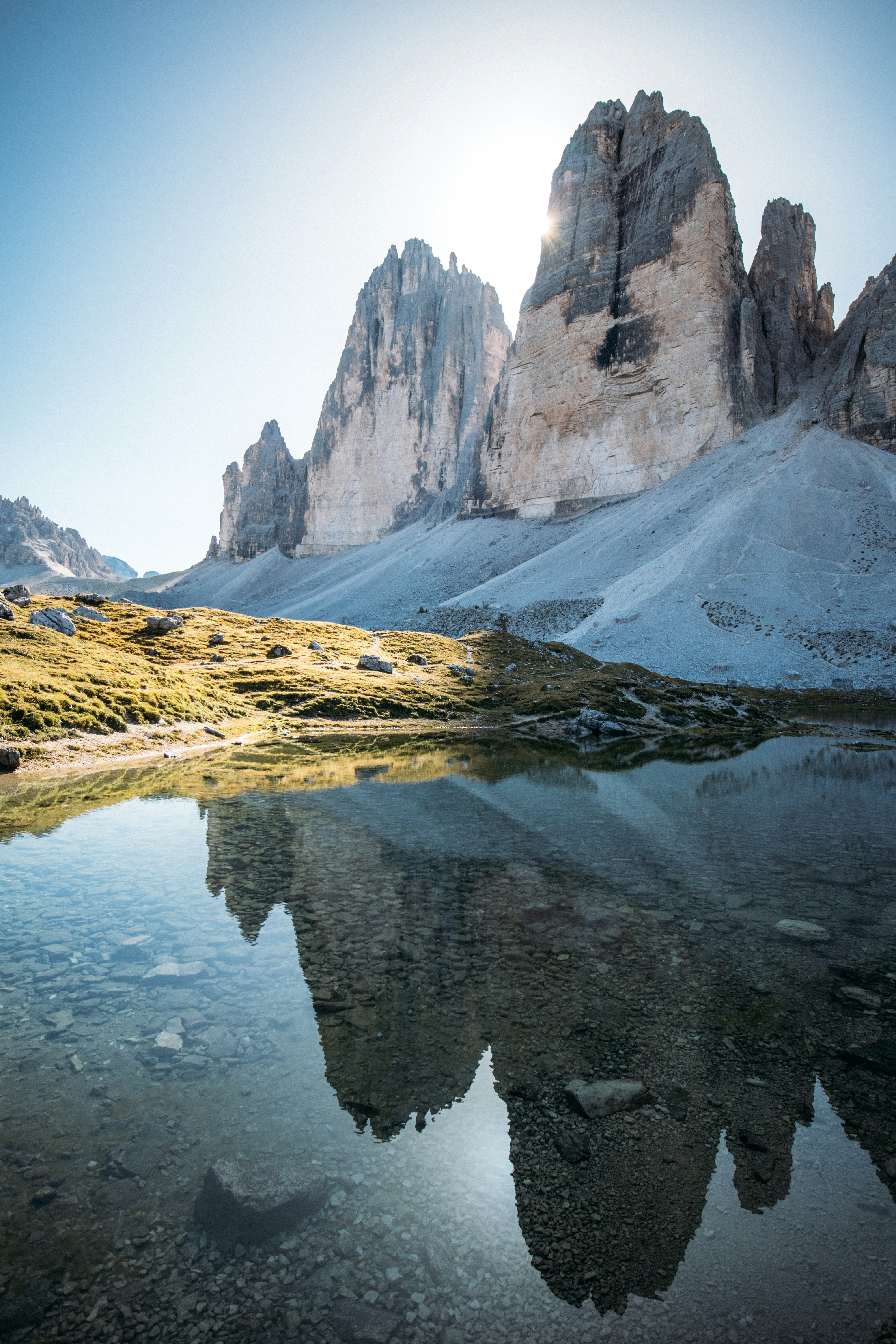 Sunlit alpine peaks reflecting in a tranquil mountain lake.