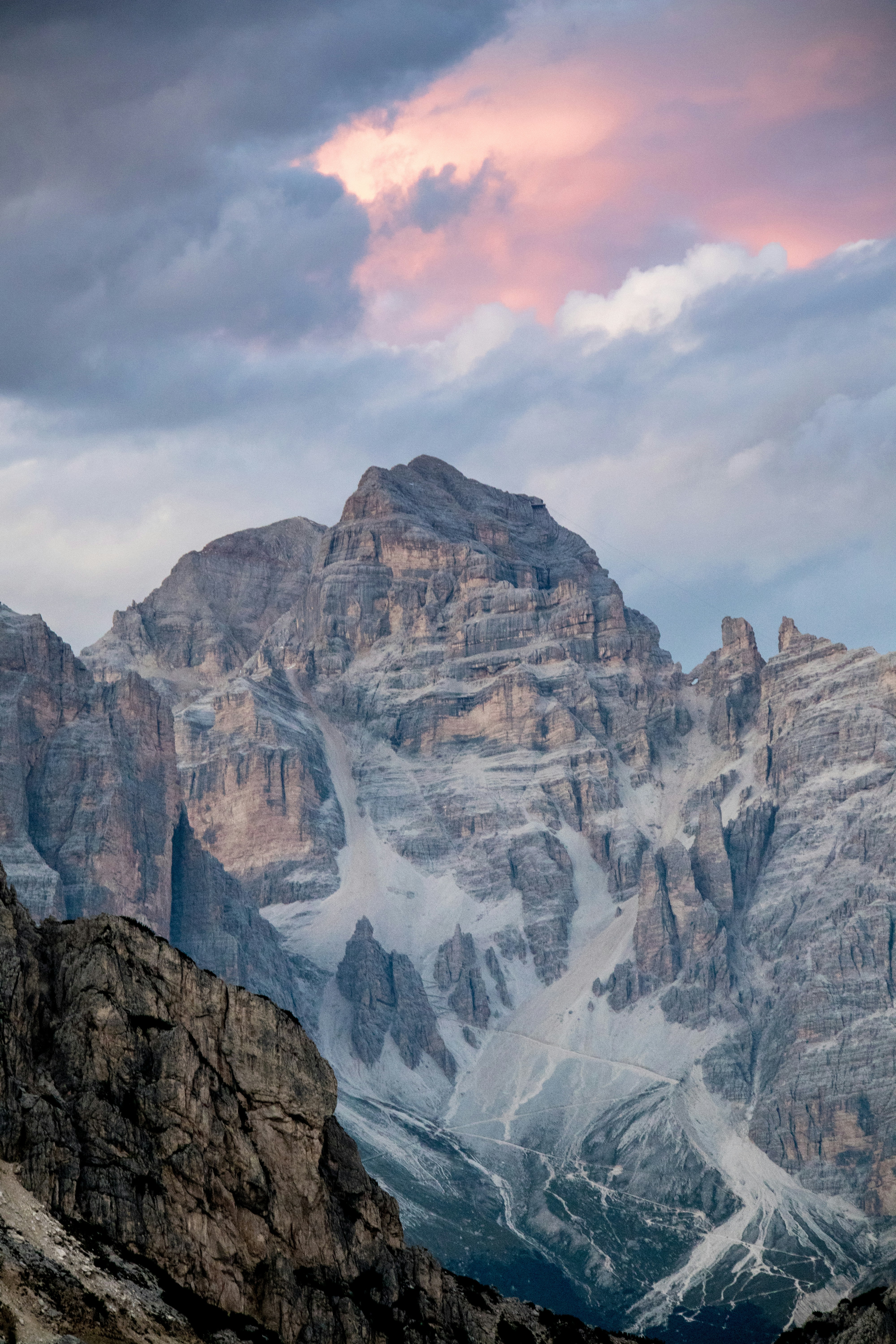 Majestic mountain peak under a dramatic sky with pink clouds.