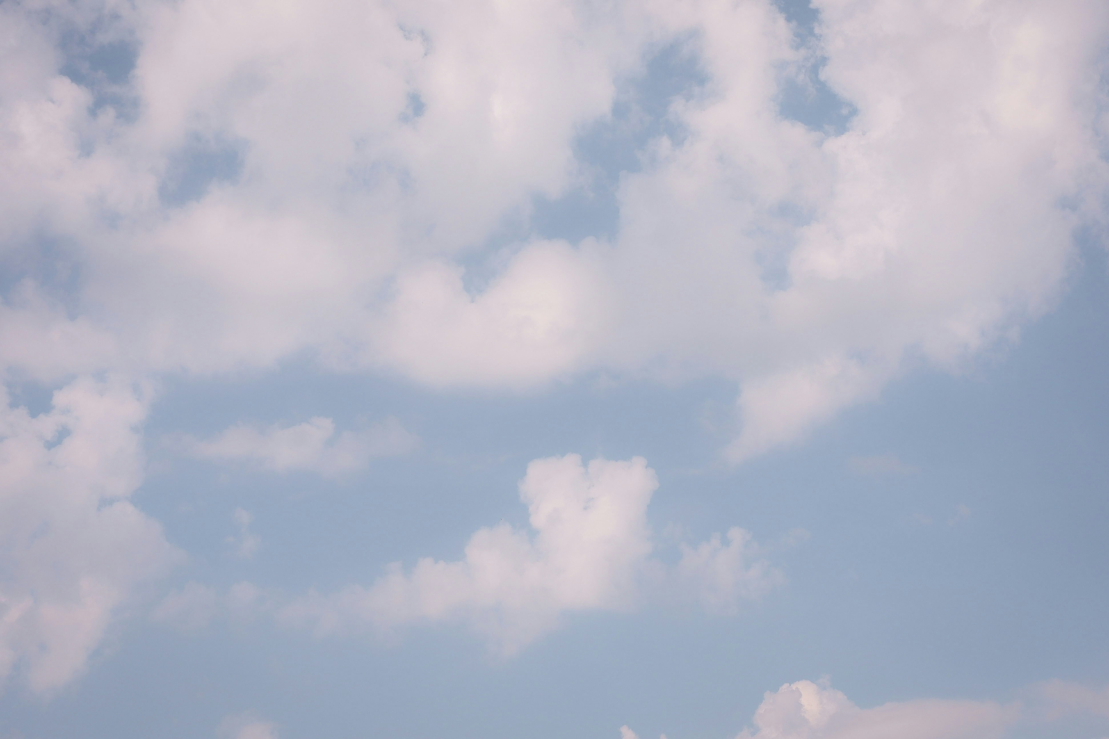 Light blue sky with scattered white clouds