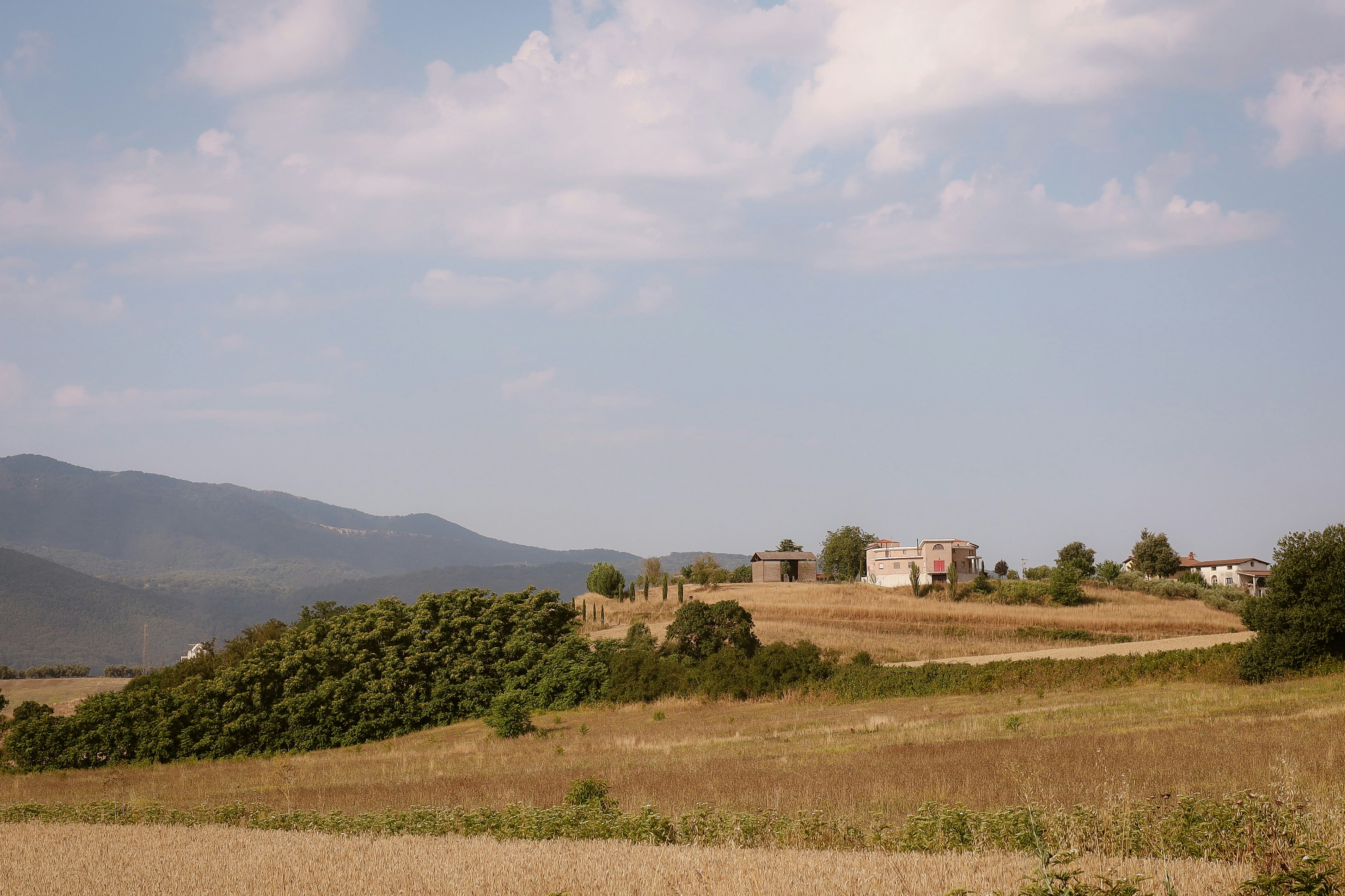 Dry fields and old buildings on rural hillside