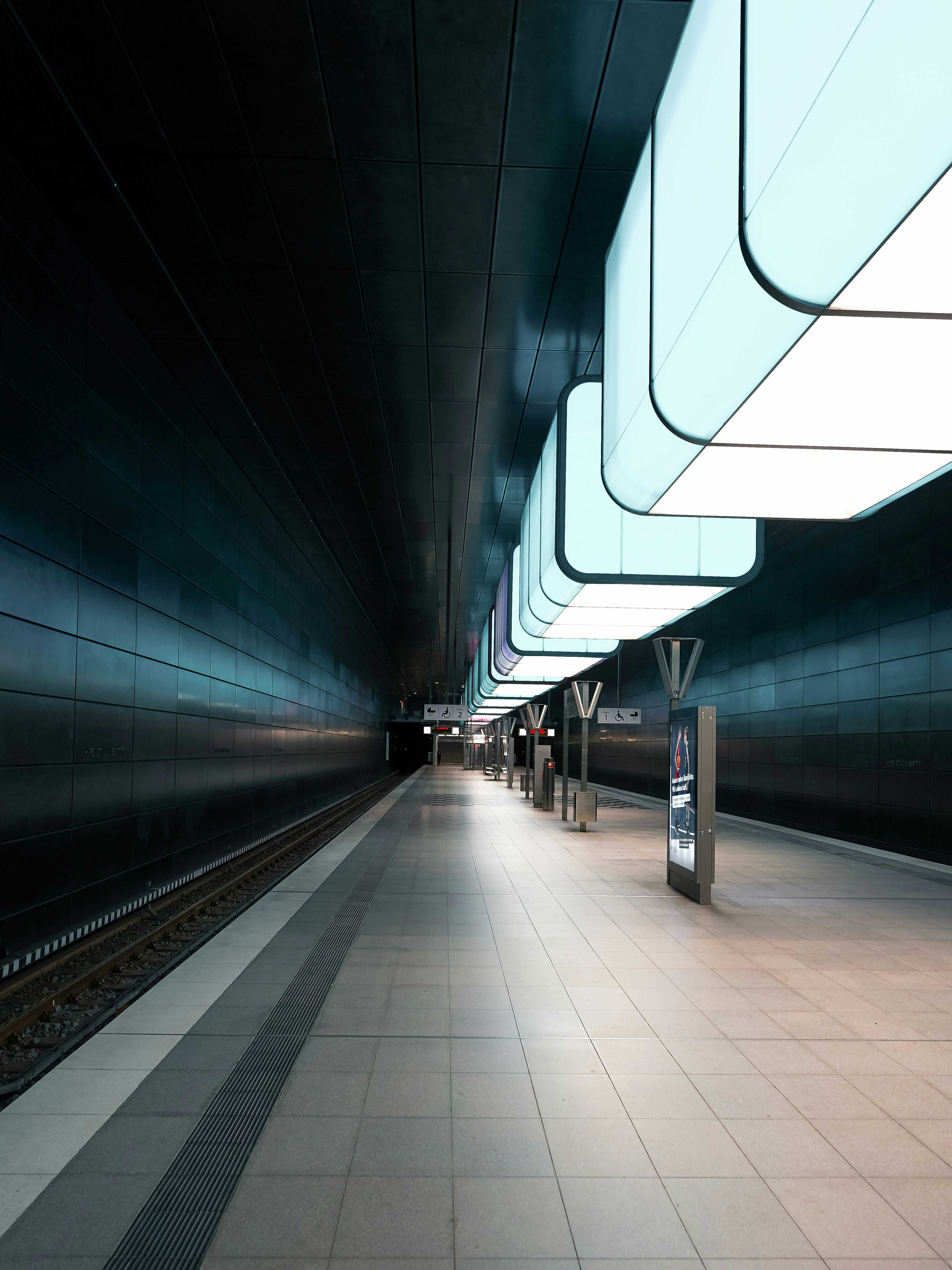 Modern, empty subway station platform with futuristic lighting.