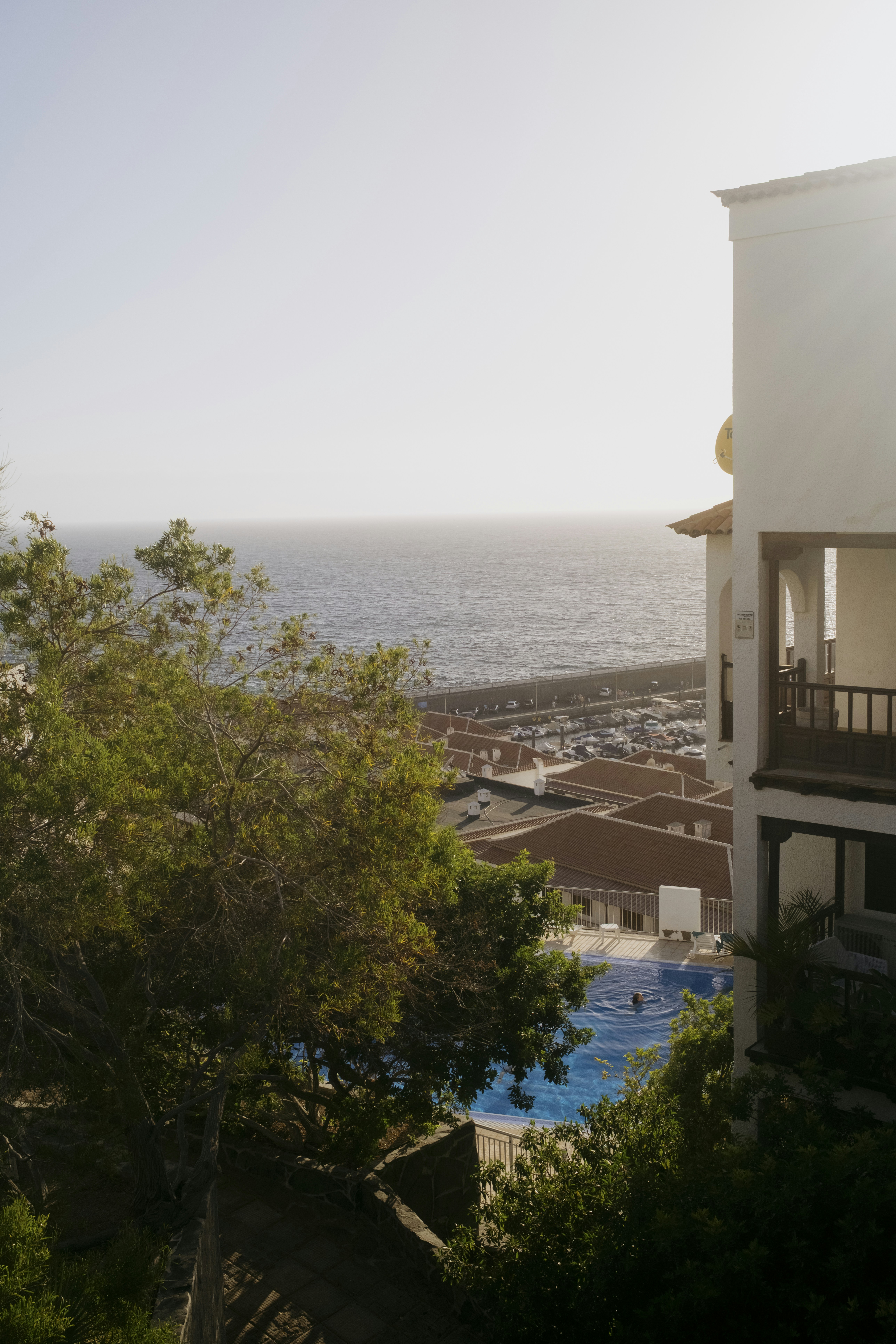 Resort building overlooking ocean, harbor, and swimming pool.