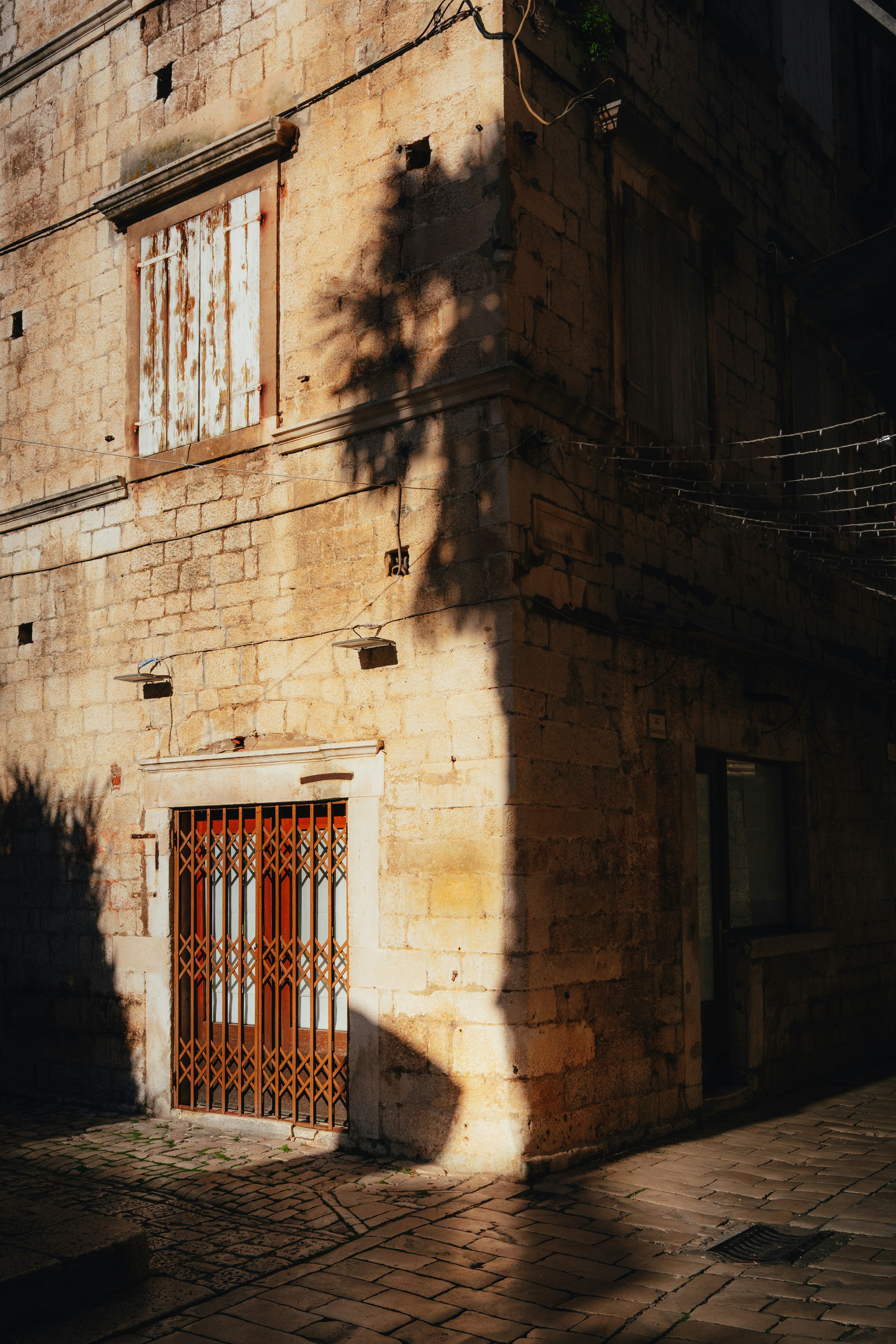 Sunlit old stone building corner in trogir