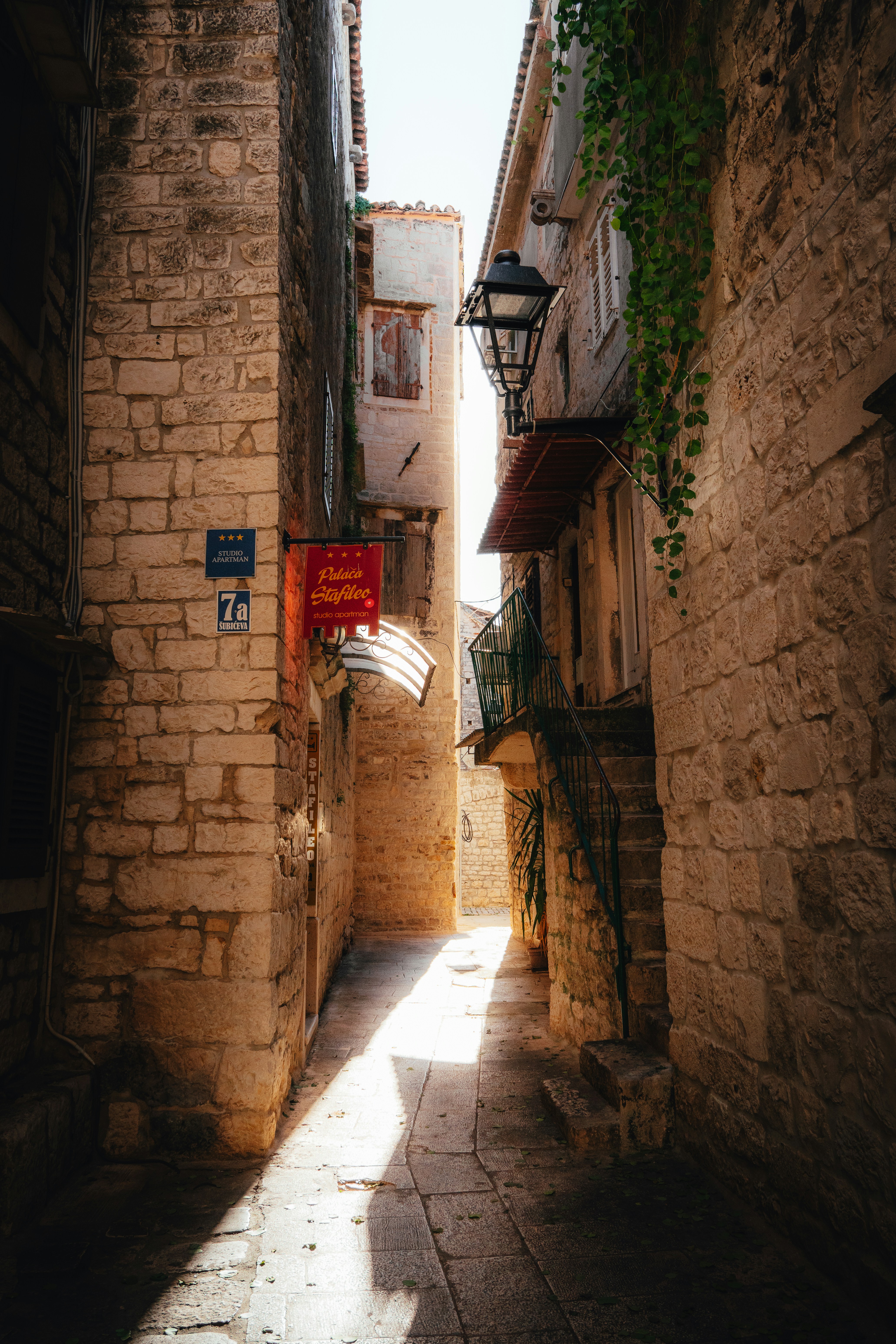Sunlight illuminates narrow stone alley in trogir, croatia