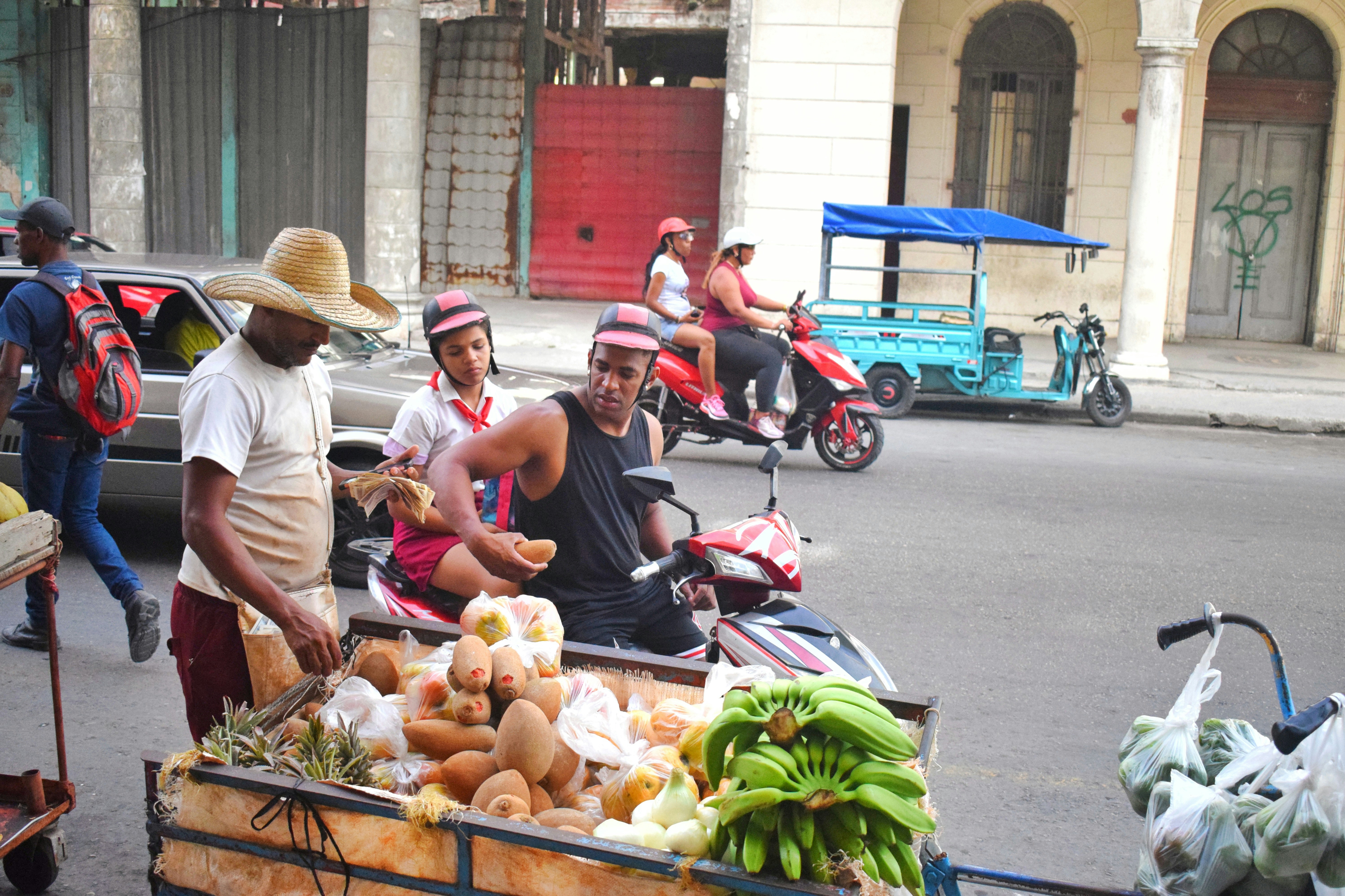 Street vendor selling fresh produce from a cart.