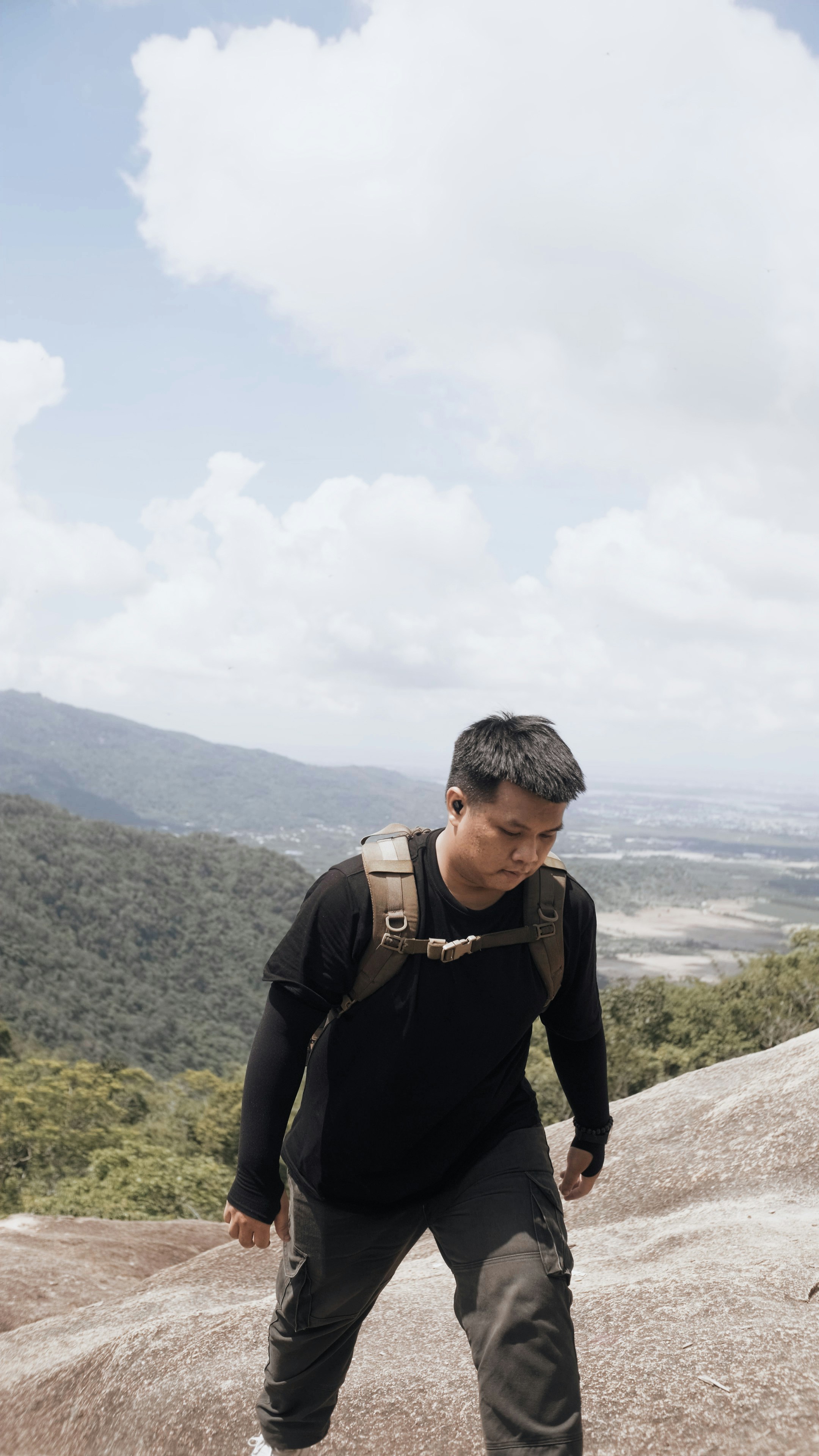 Hiker with backpack walking uphill on a rocky mountain