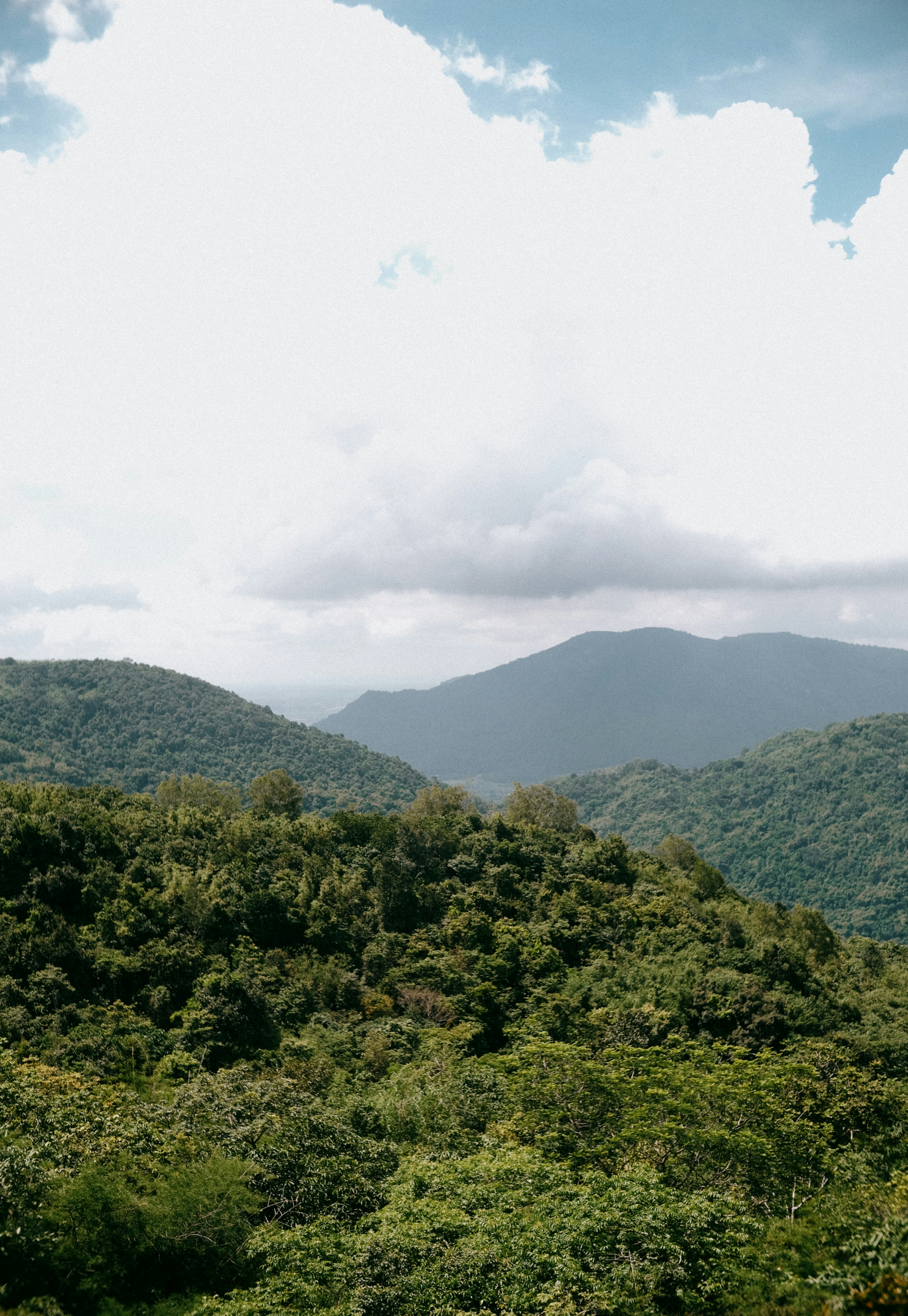 Lush green mountains under a cloudy sky