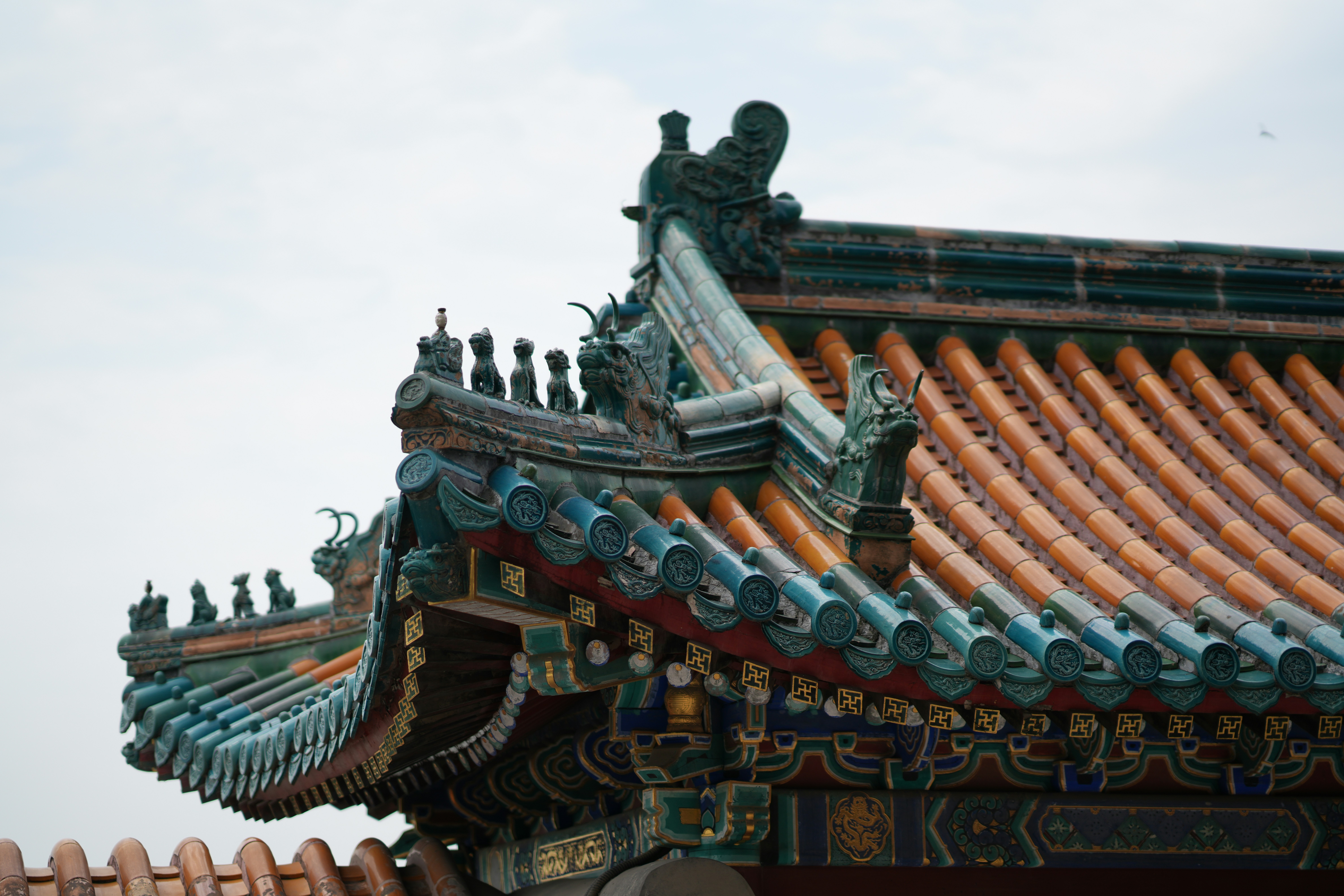 Ornate traditional chinese temple roof with green and orange tiles.