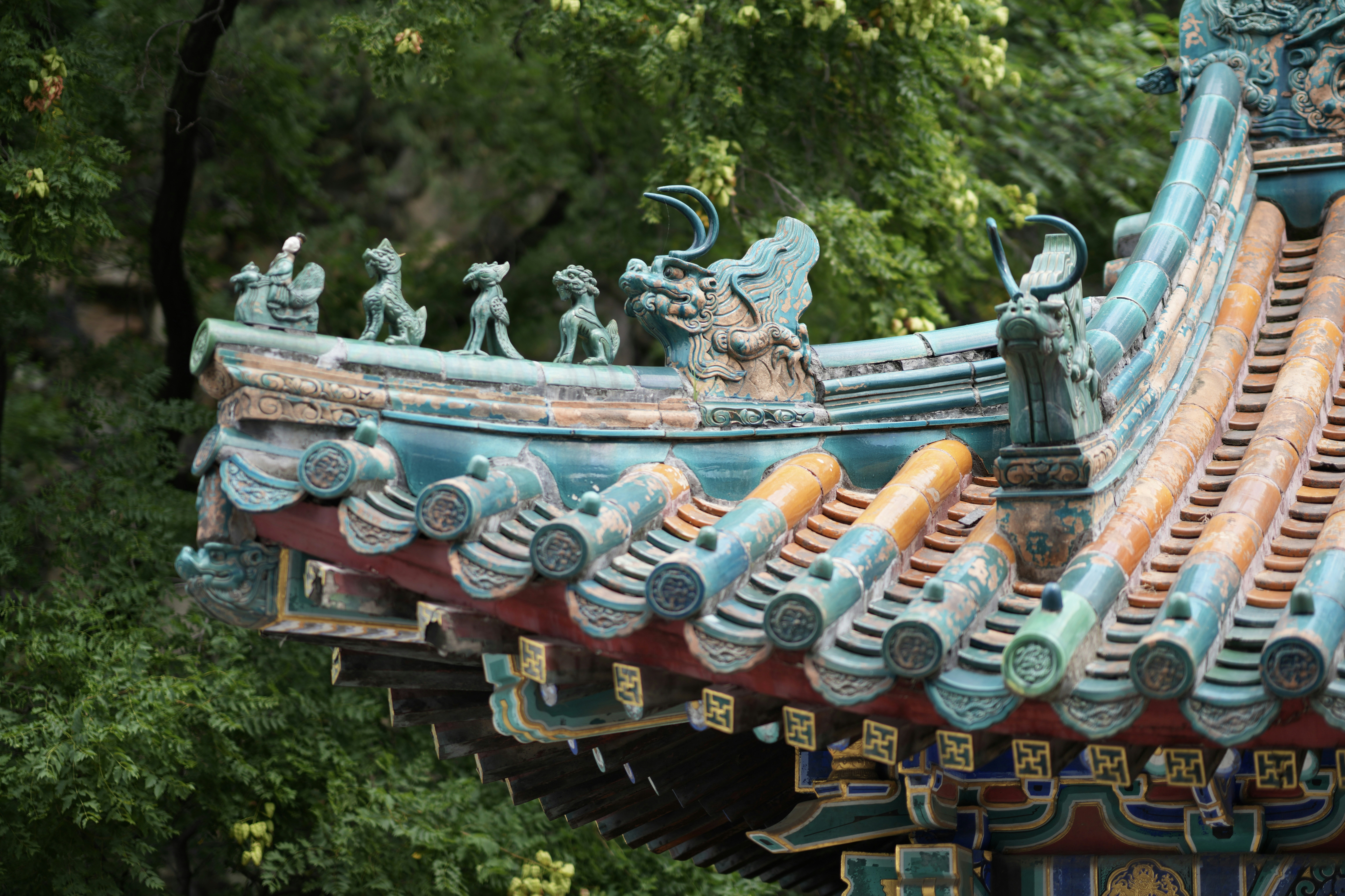 Traditional chinese temple roof with ornate, colorful animal figures.