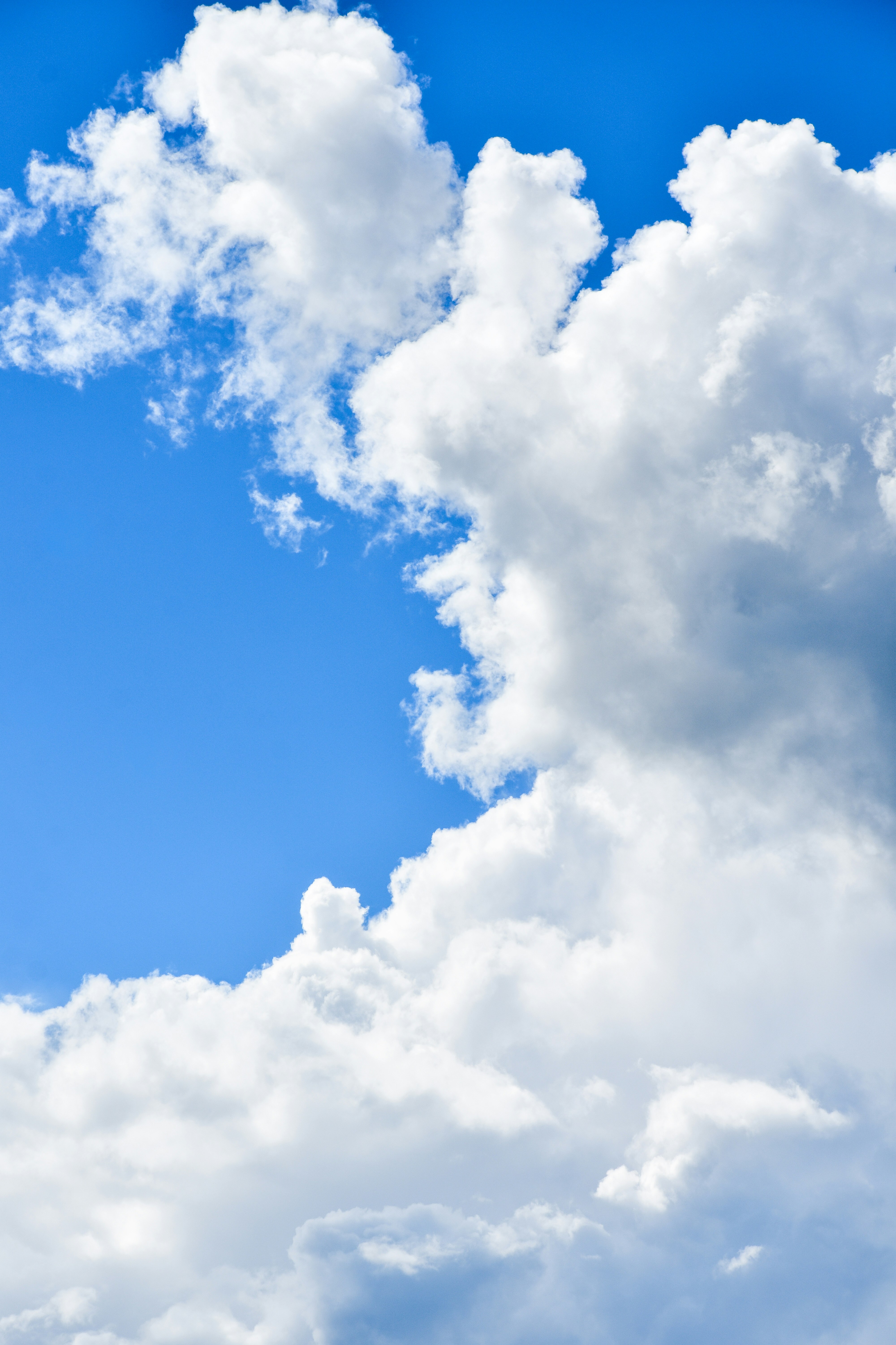 Fluffy white clouds against a vibrant blue sky