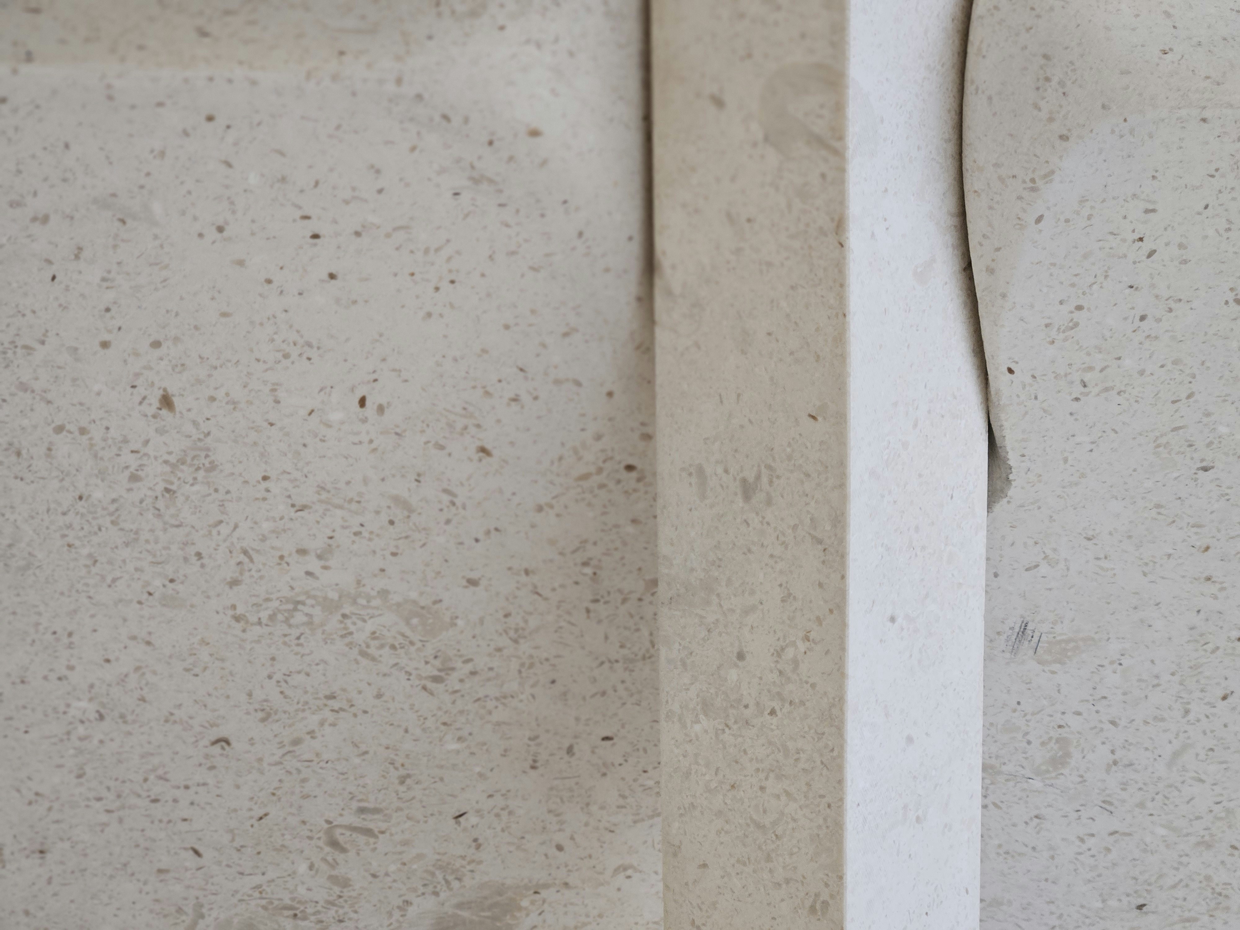 A textured light wall with peeling tape.