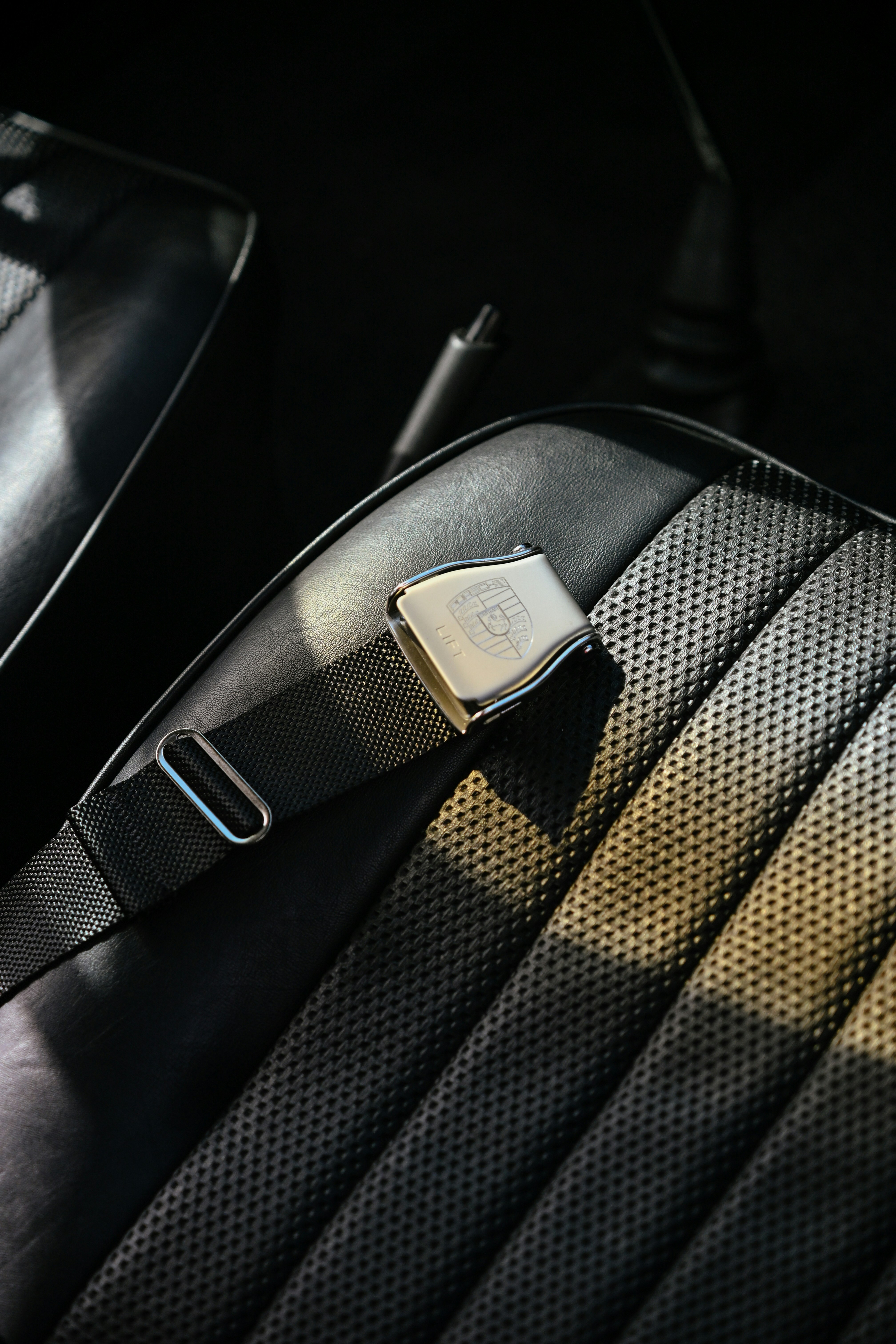 Porsche seatbelt buckle on vintage black car seat