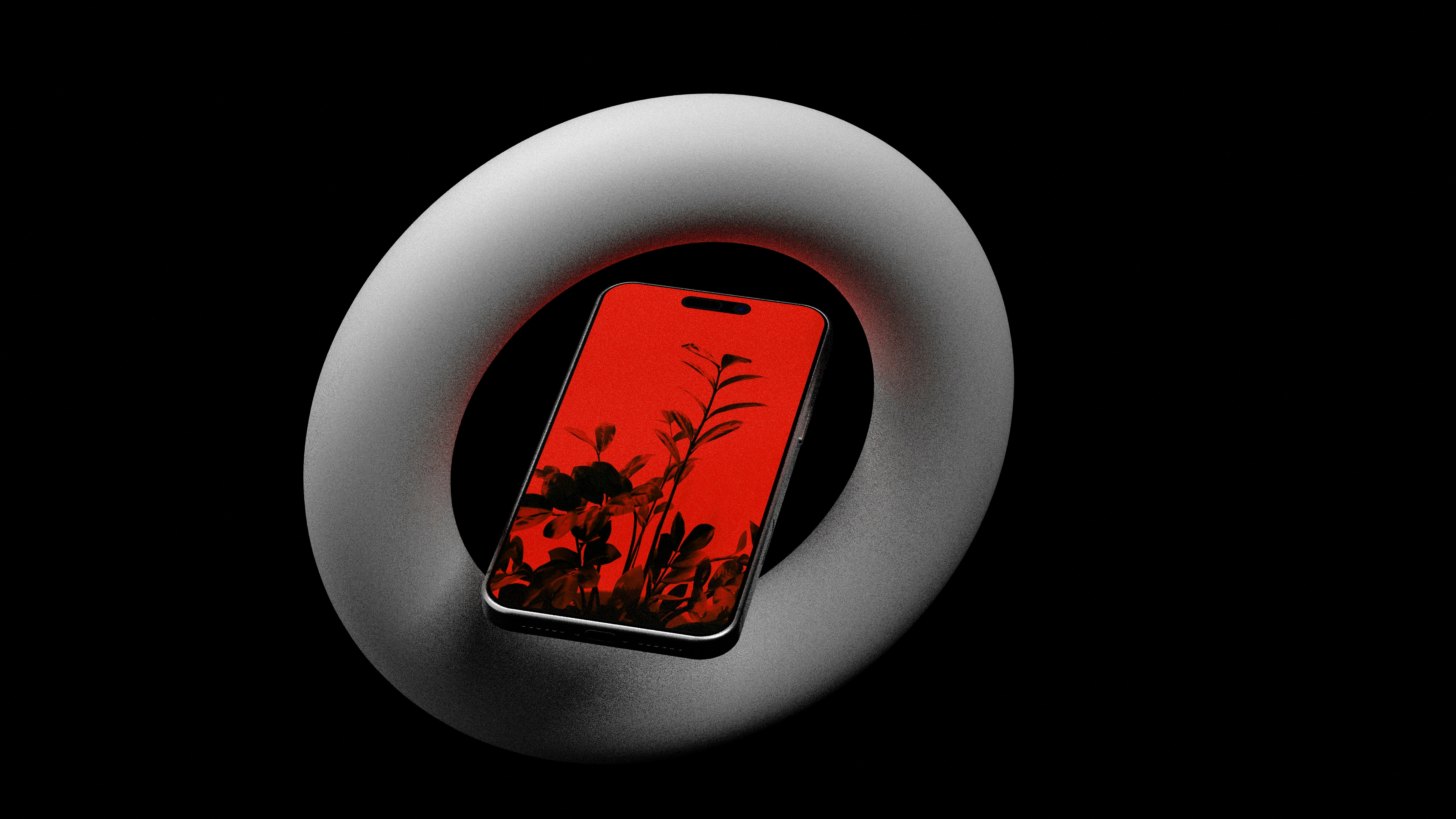 Phone displaying red foliage silhouette inside a white torus.