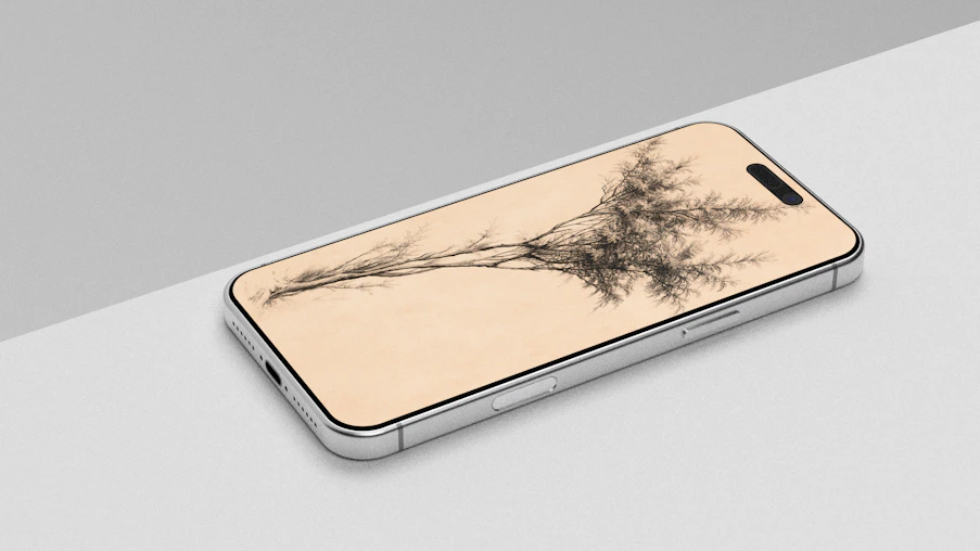 A silver smartphone displays a tree on a light background