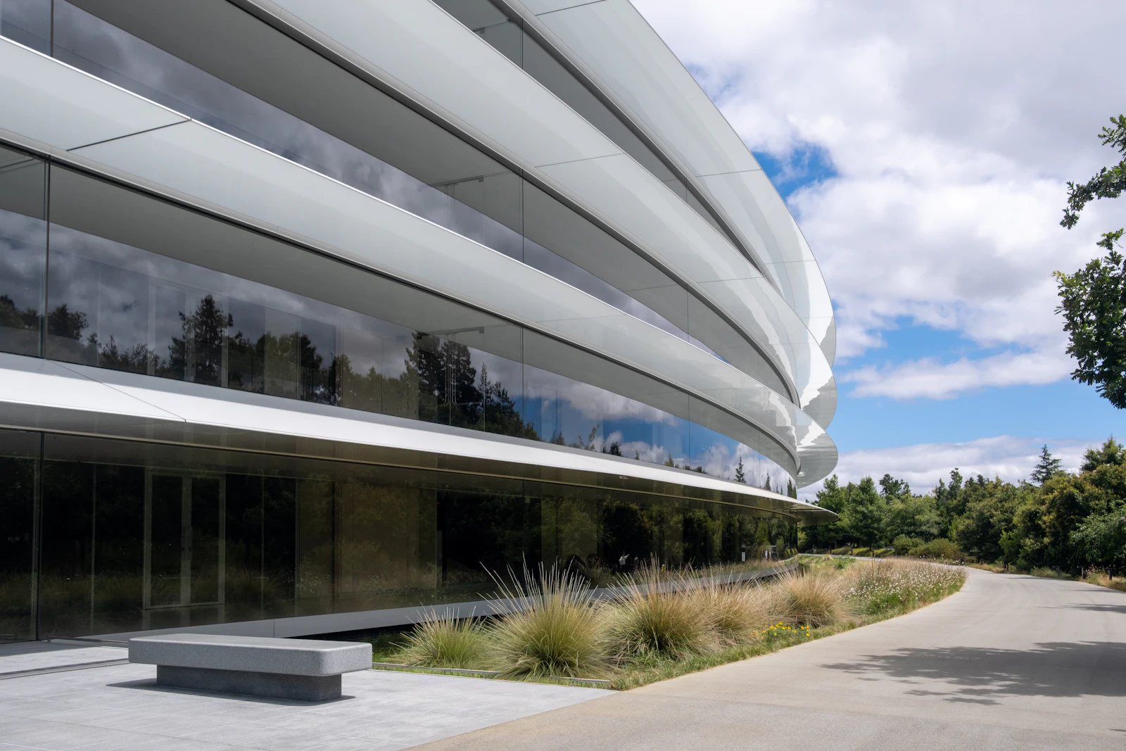 Modern curved glass corporate building with landscaping