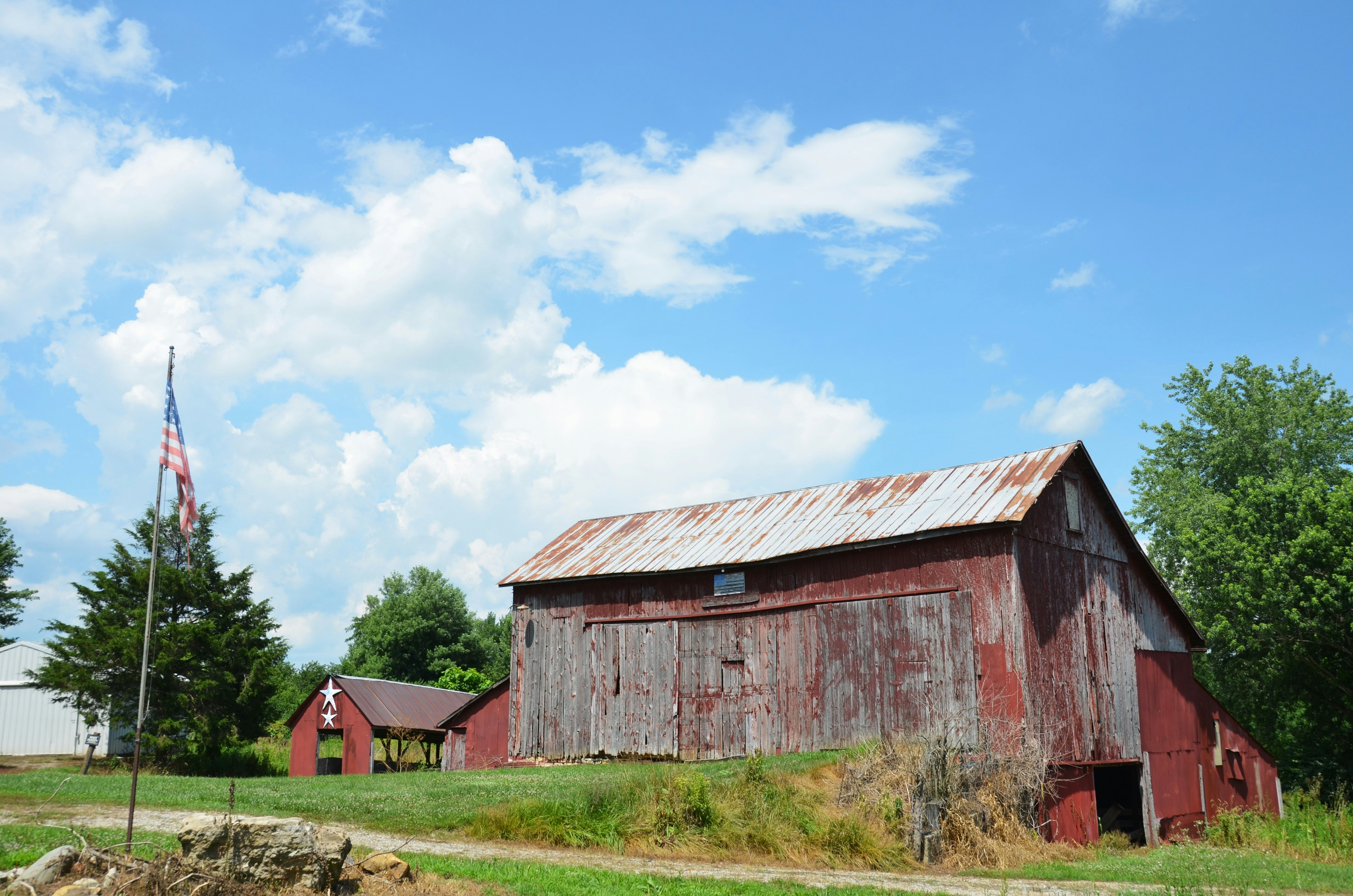 Stock photo: a rustic red barn with an American flag against a blue sky