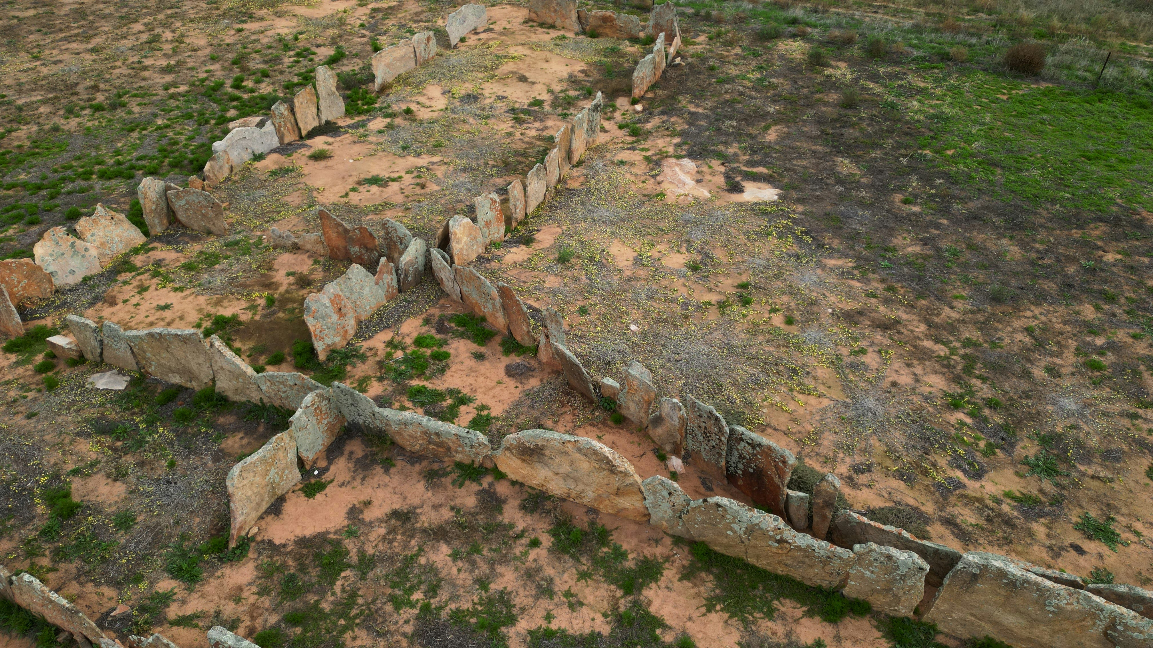 Aerial view of ancient stone ruins in a dry landscape.