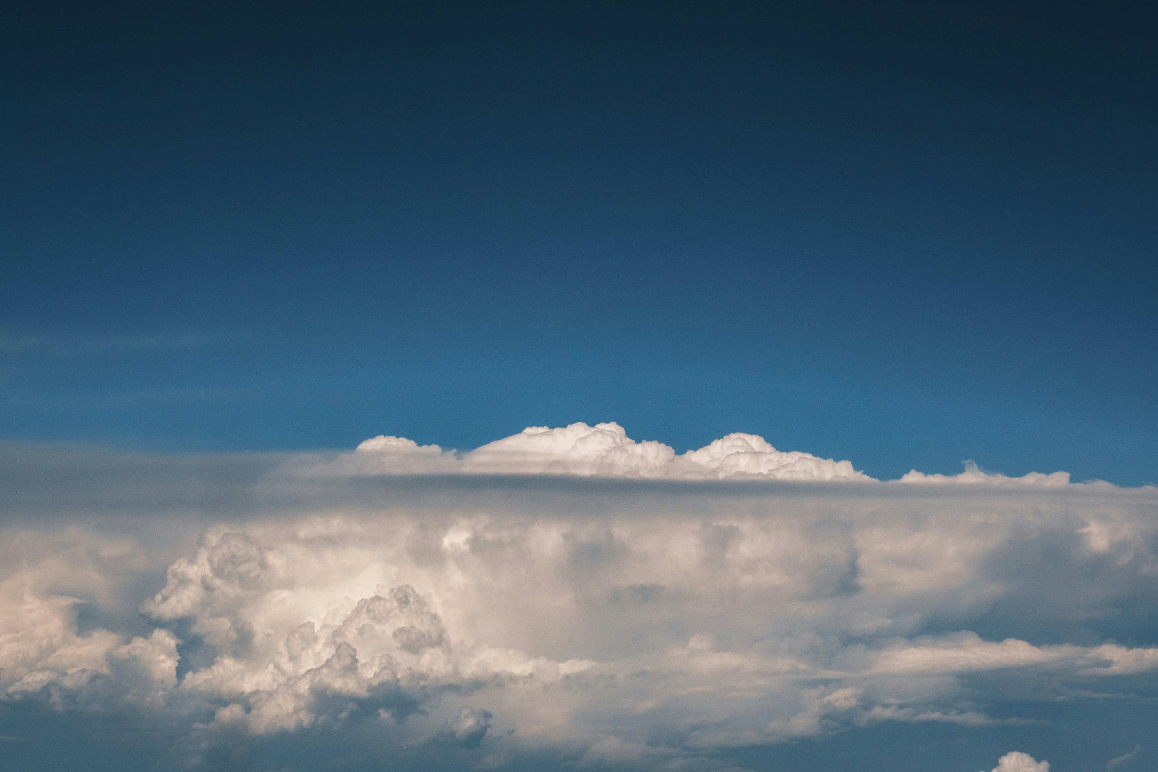 Blue sky above a wide layer of white, fluffy clouds.