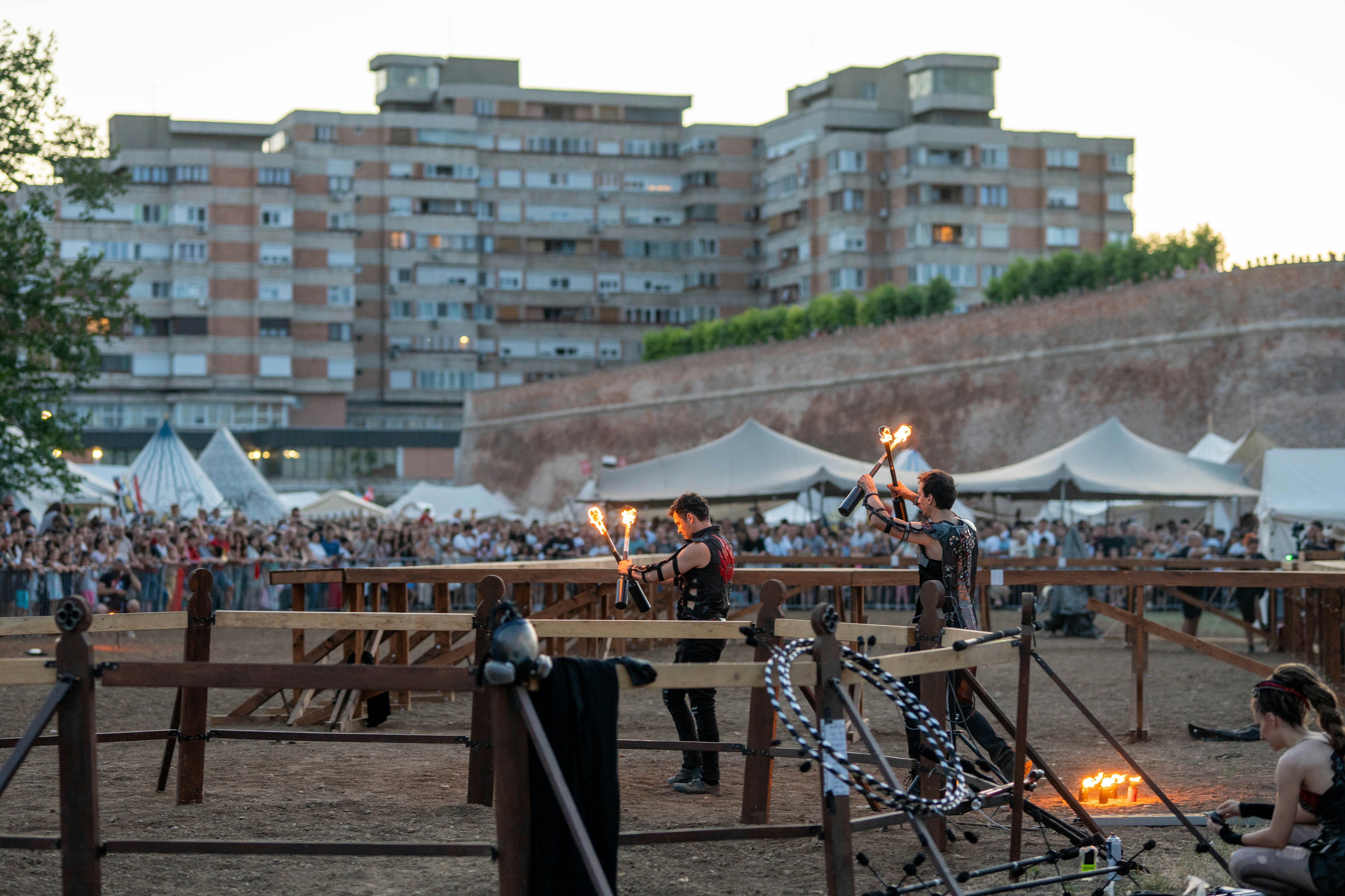 Performers with fire entertain a crowd at a medieval event.