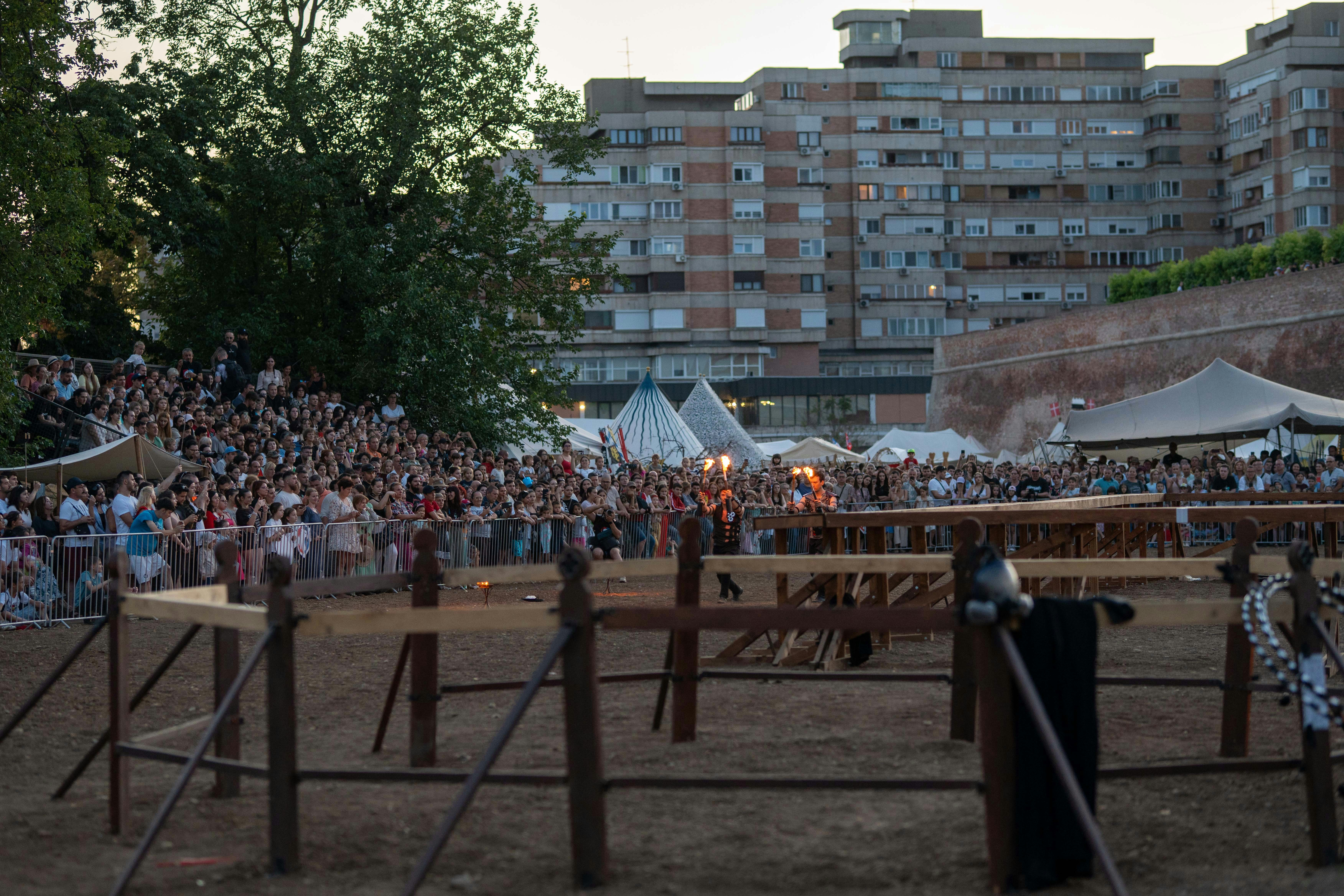 Large crowd gathered for an outdoor event near urban buildings.