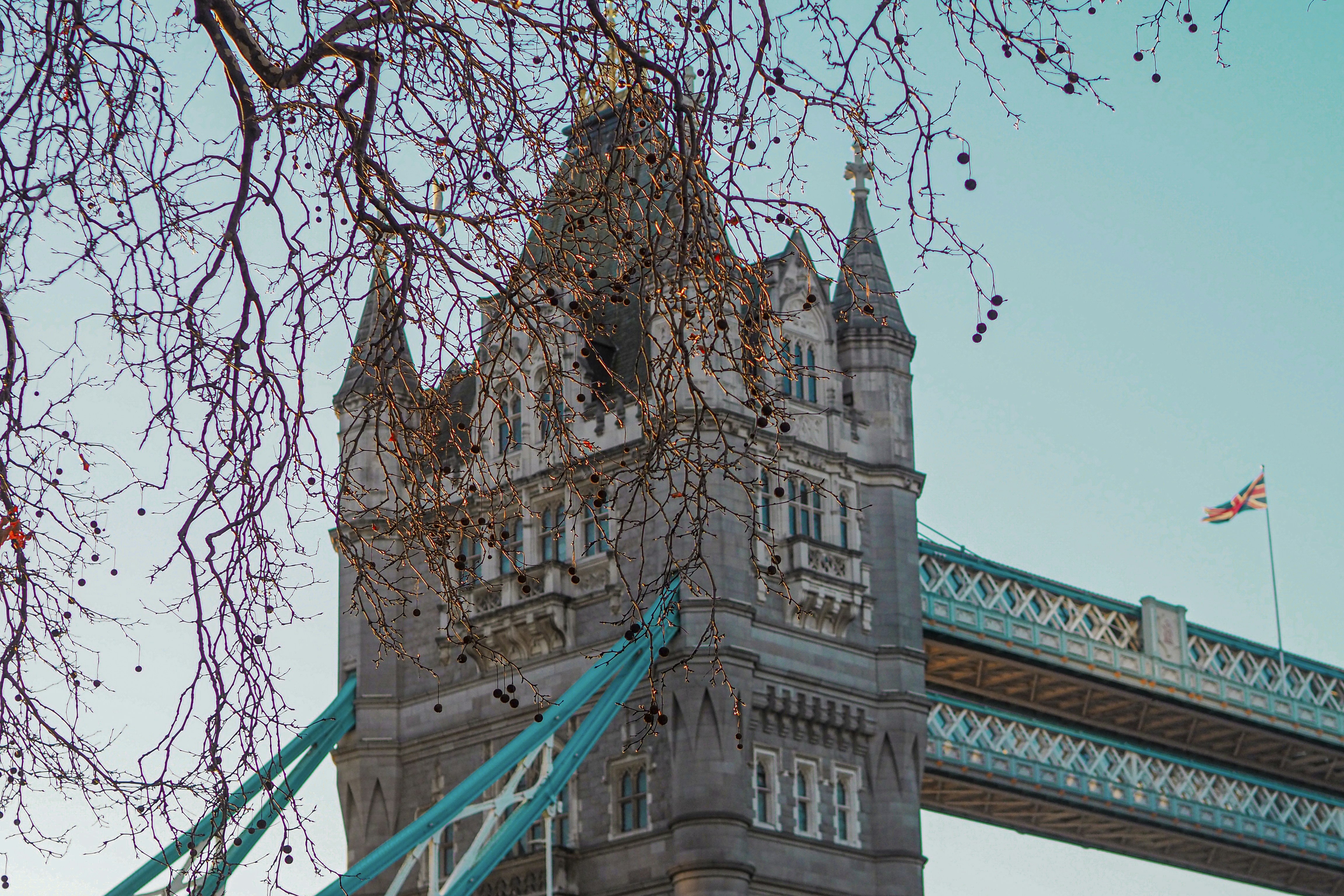 Iconica torre con il ponte con Union Jack e alberi spogli.