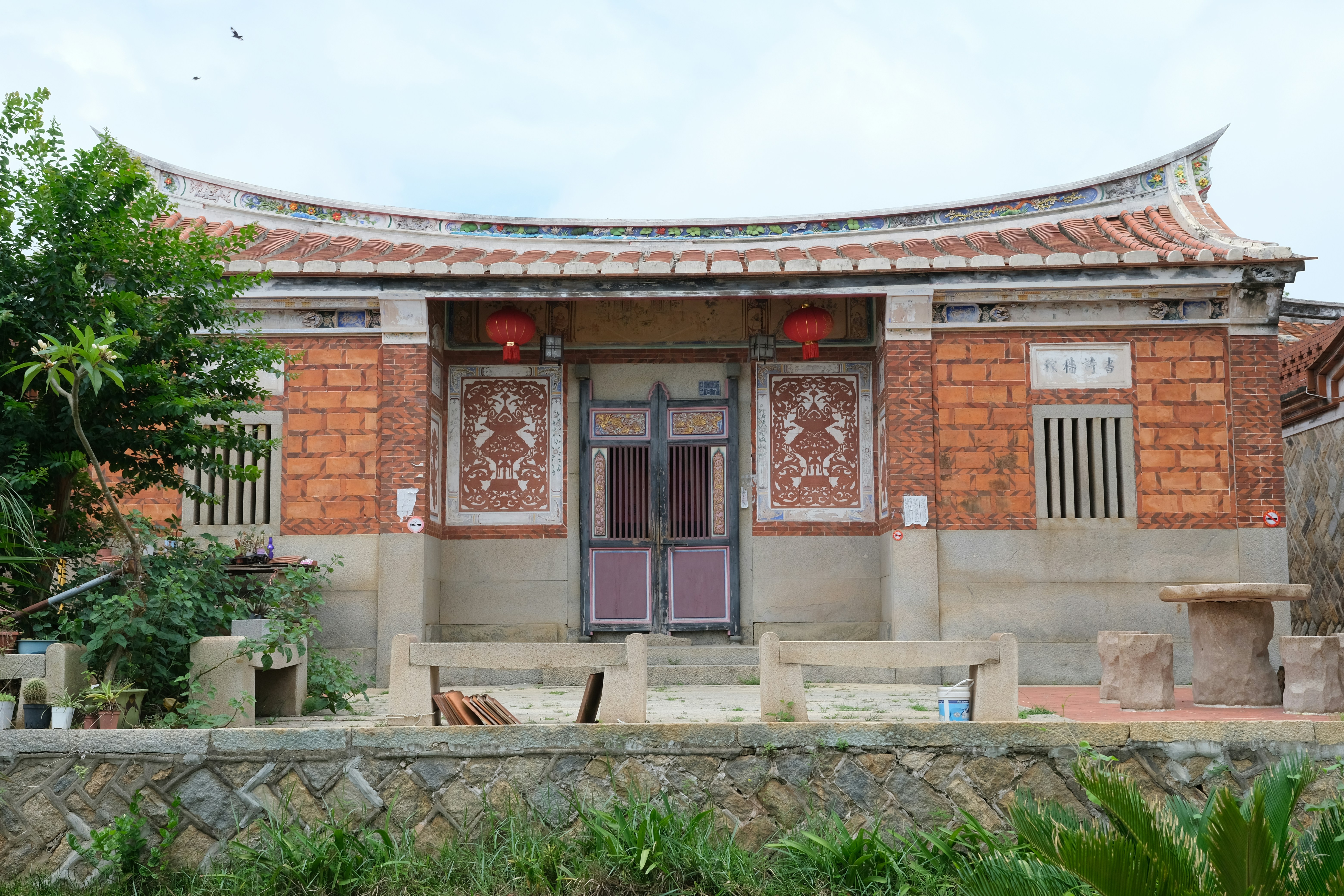 Old asian house with curved roof and red lanterns