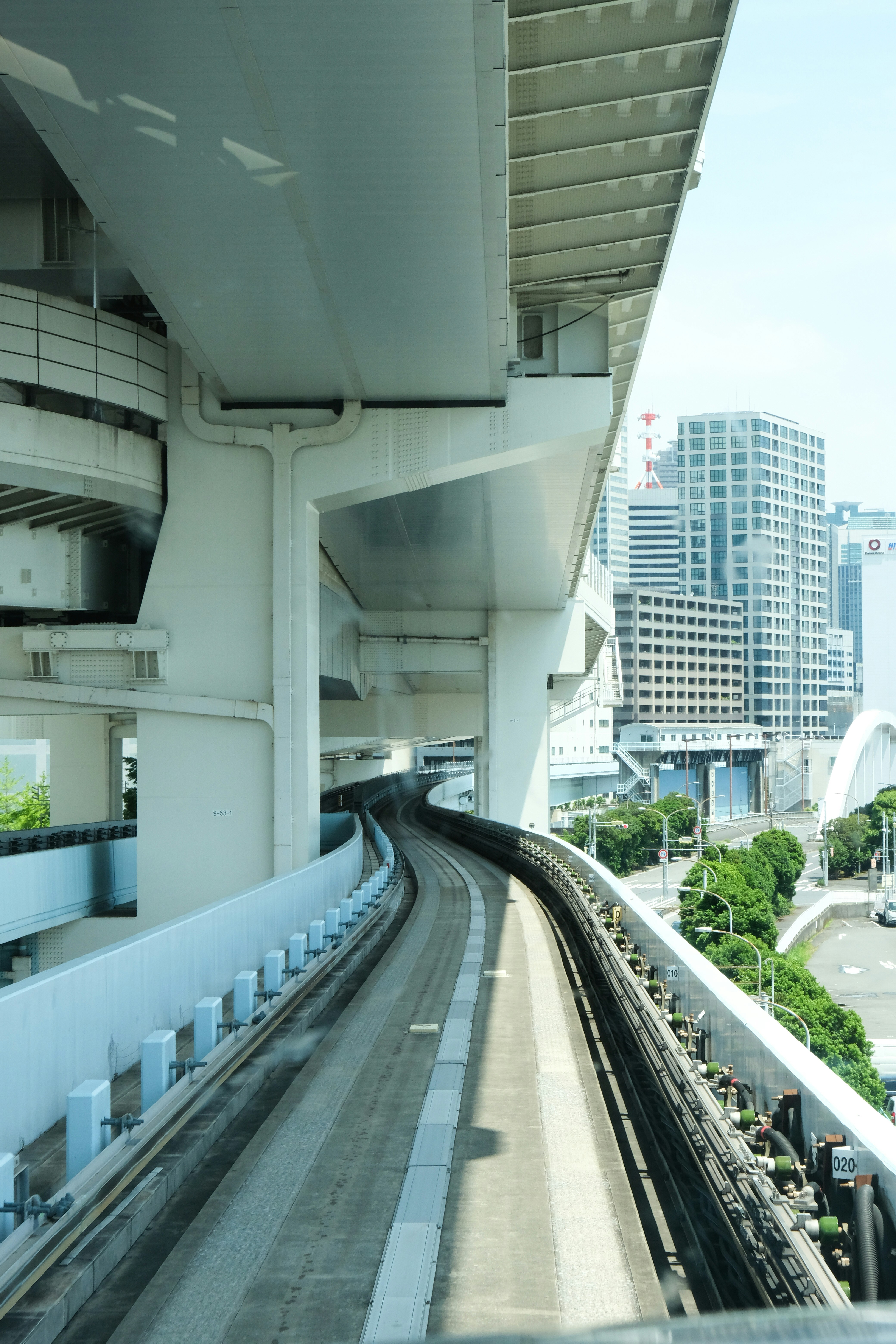 Monorail track curving under elevated city structures.