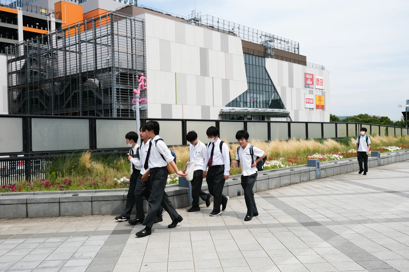 Students in uniform walking past a building in Japan