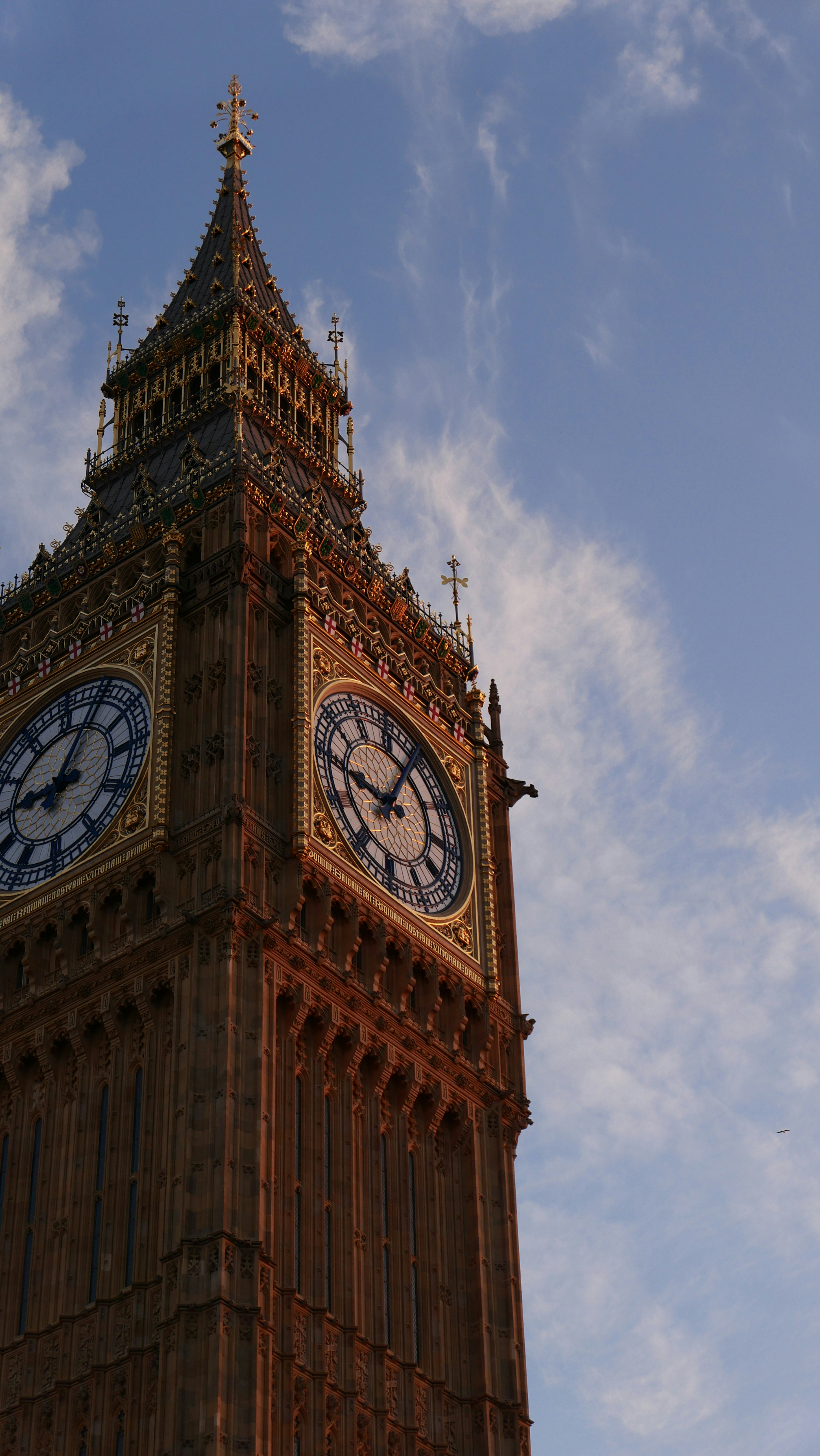 O relógio da torre Elizabeth se vira contra um céu parcialmente nublado.