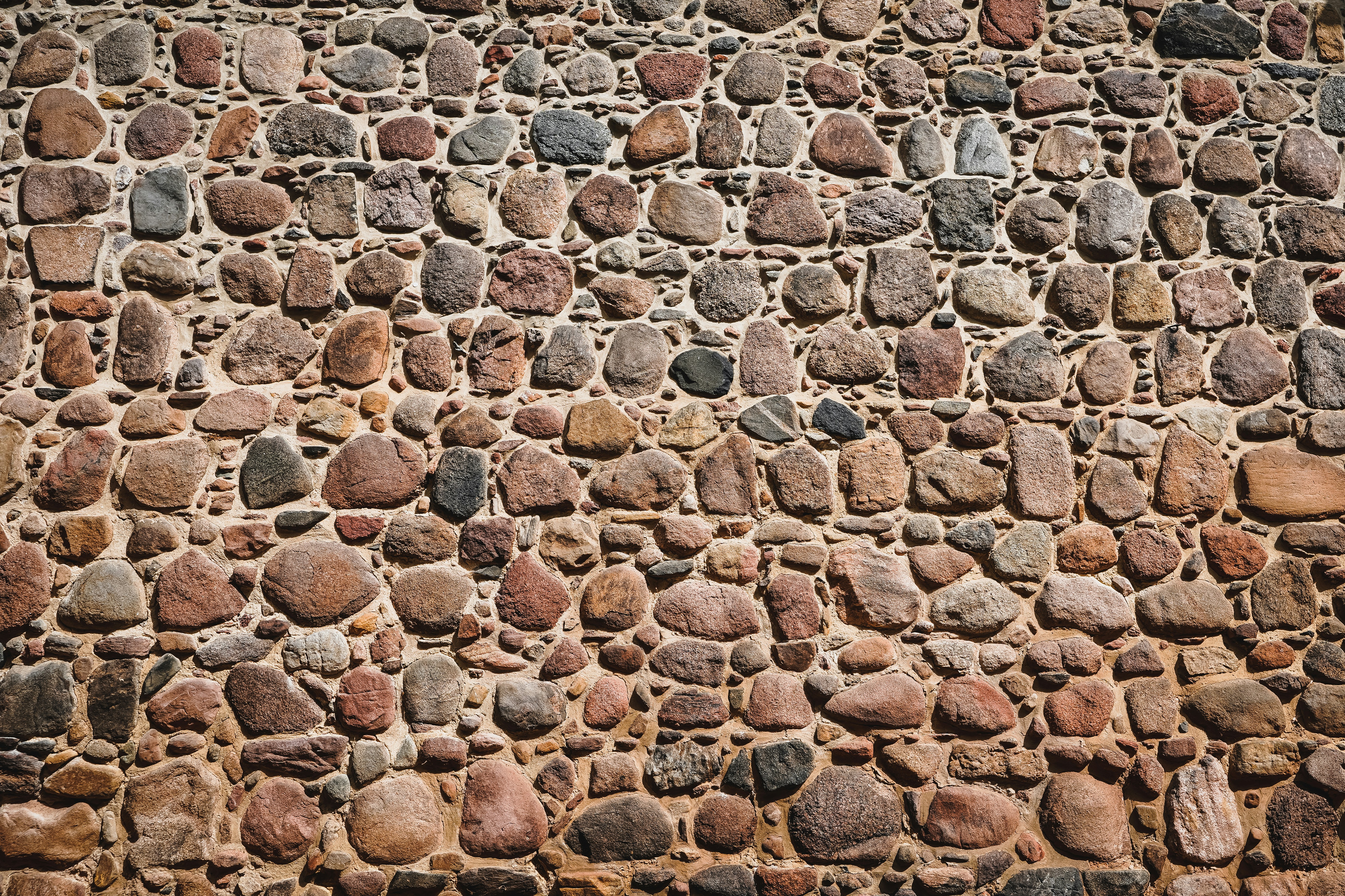 A textured wall made of various rounded stones.
