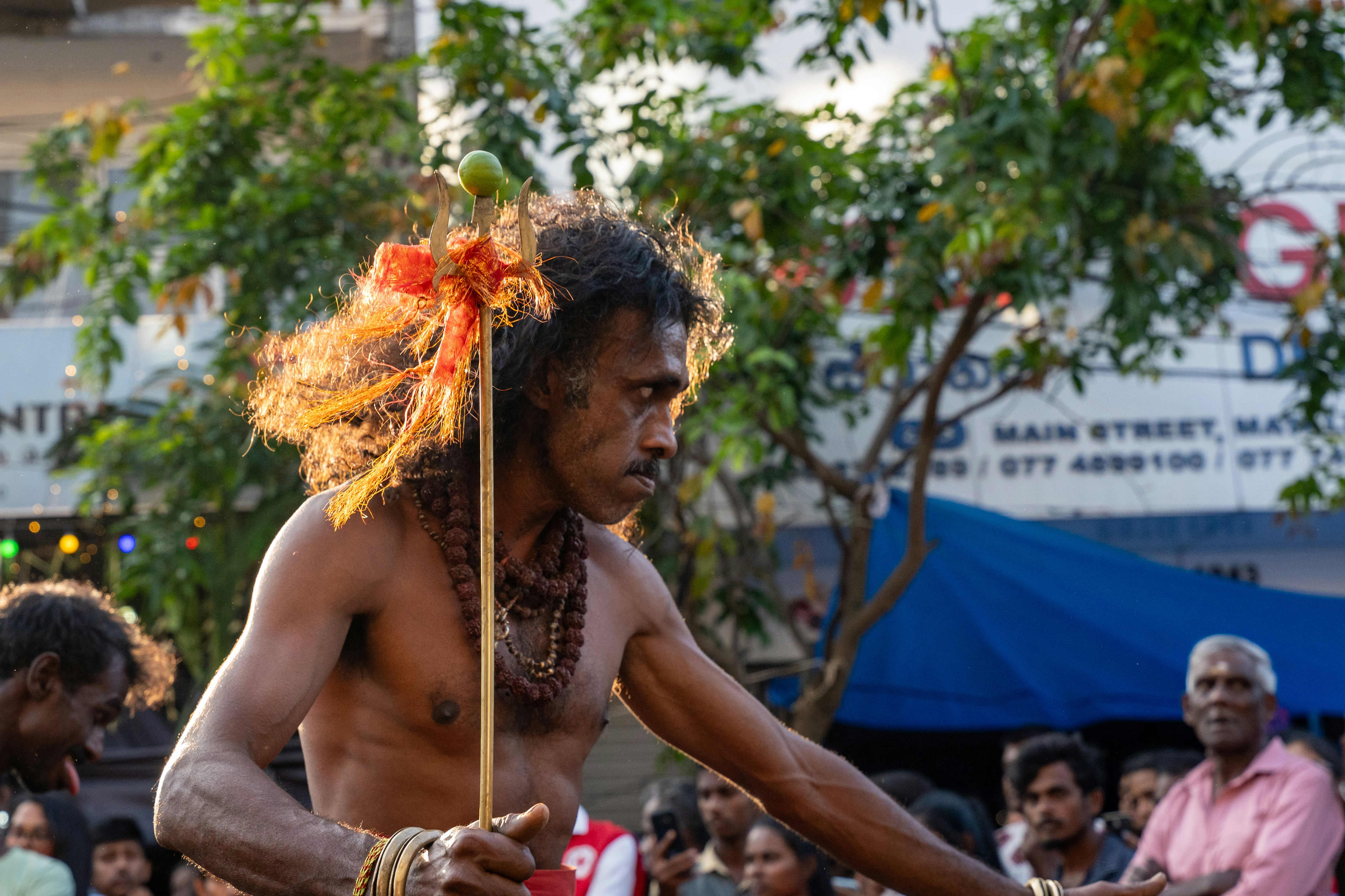 Pria dengan rambut keriting panjang memegang tongkat di luar ruangan