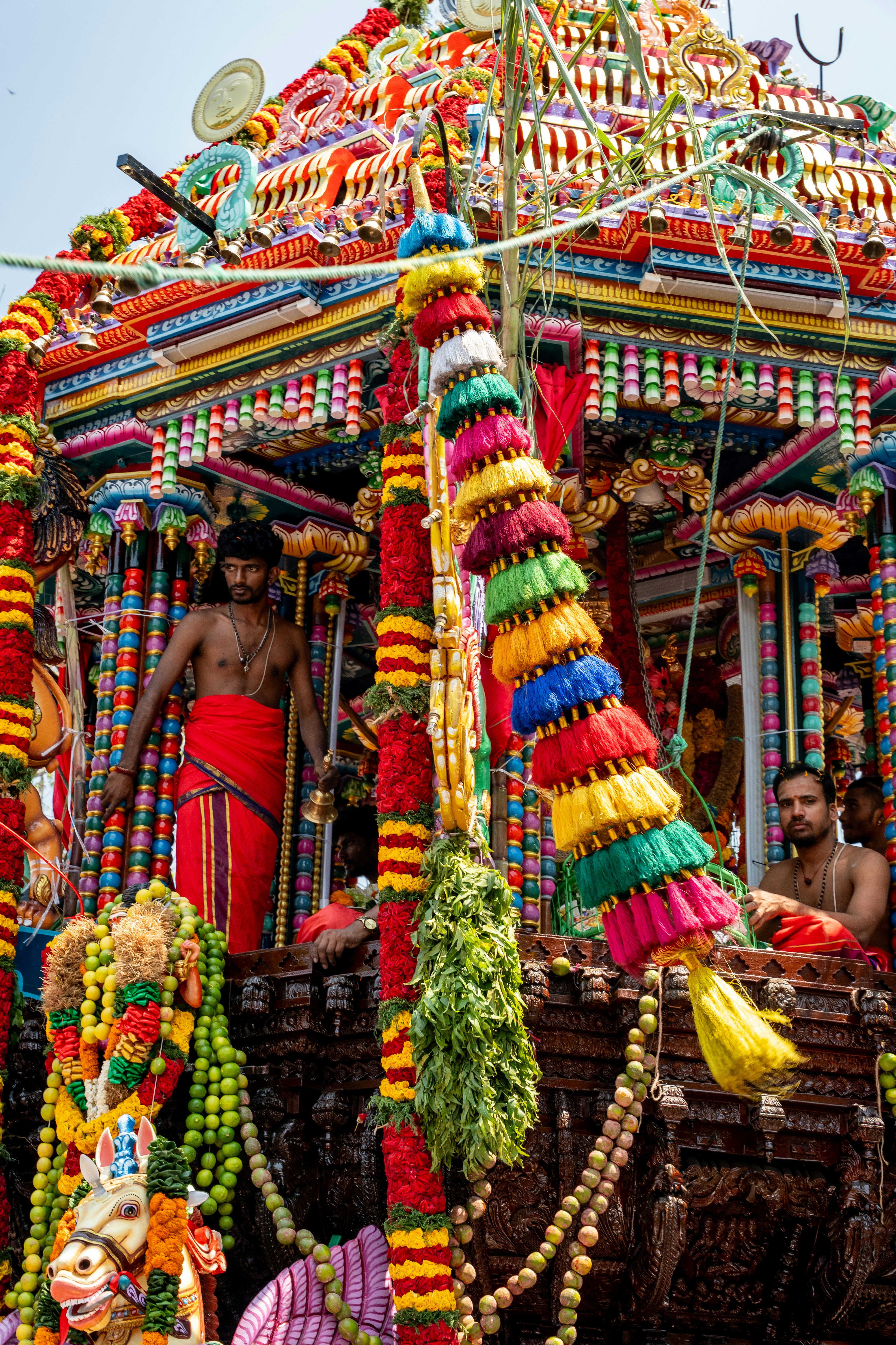 Homens em uma carruagem de templo ricamente decorada durante um festival.