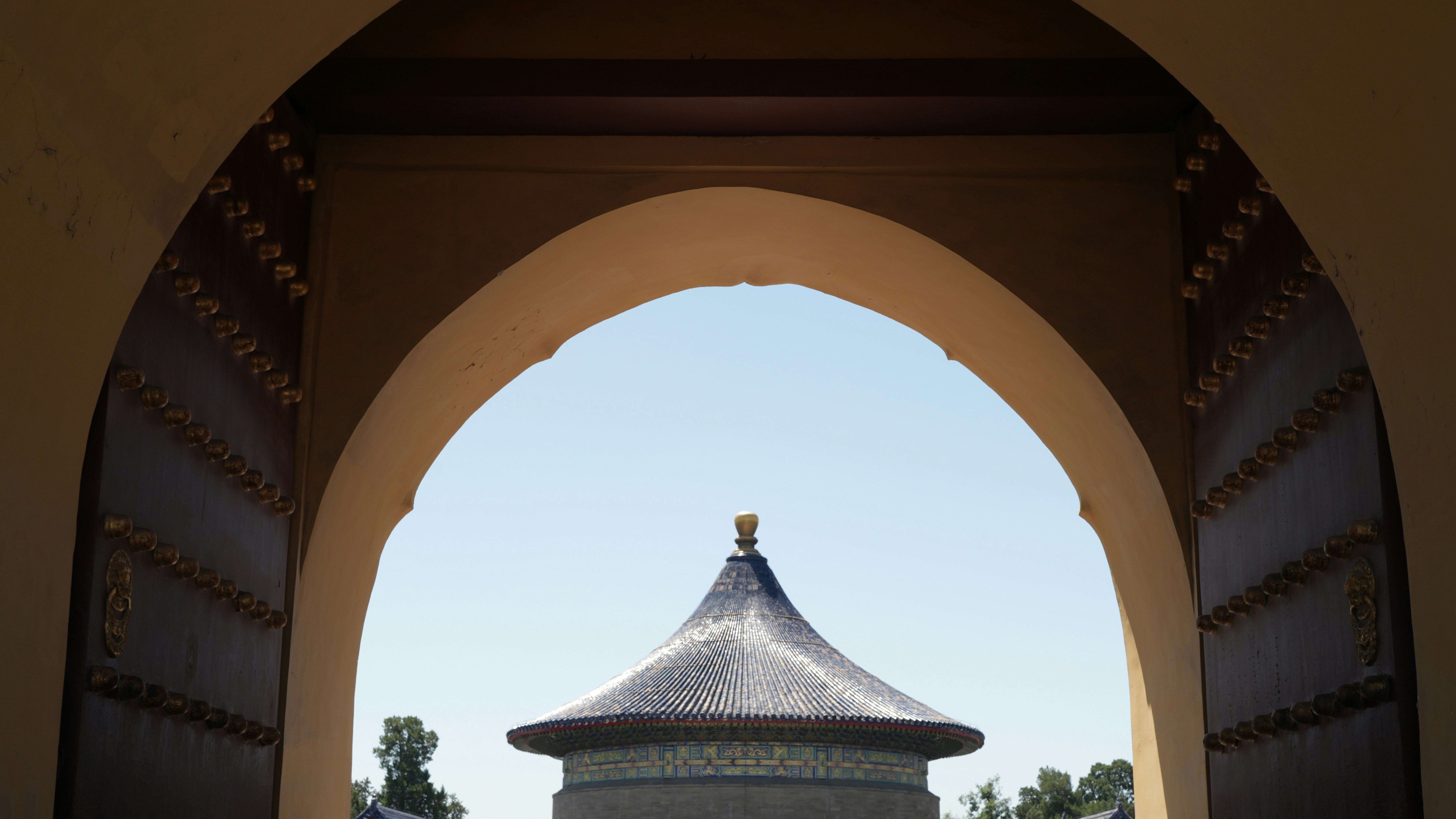 Traditional chinese roof viewed through an ornate archway.