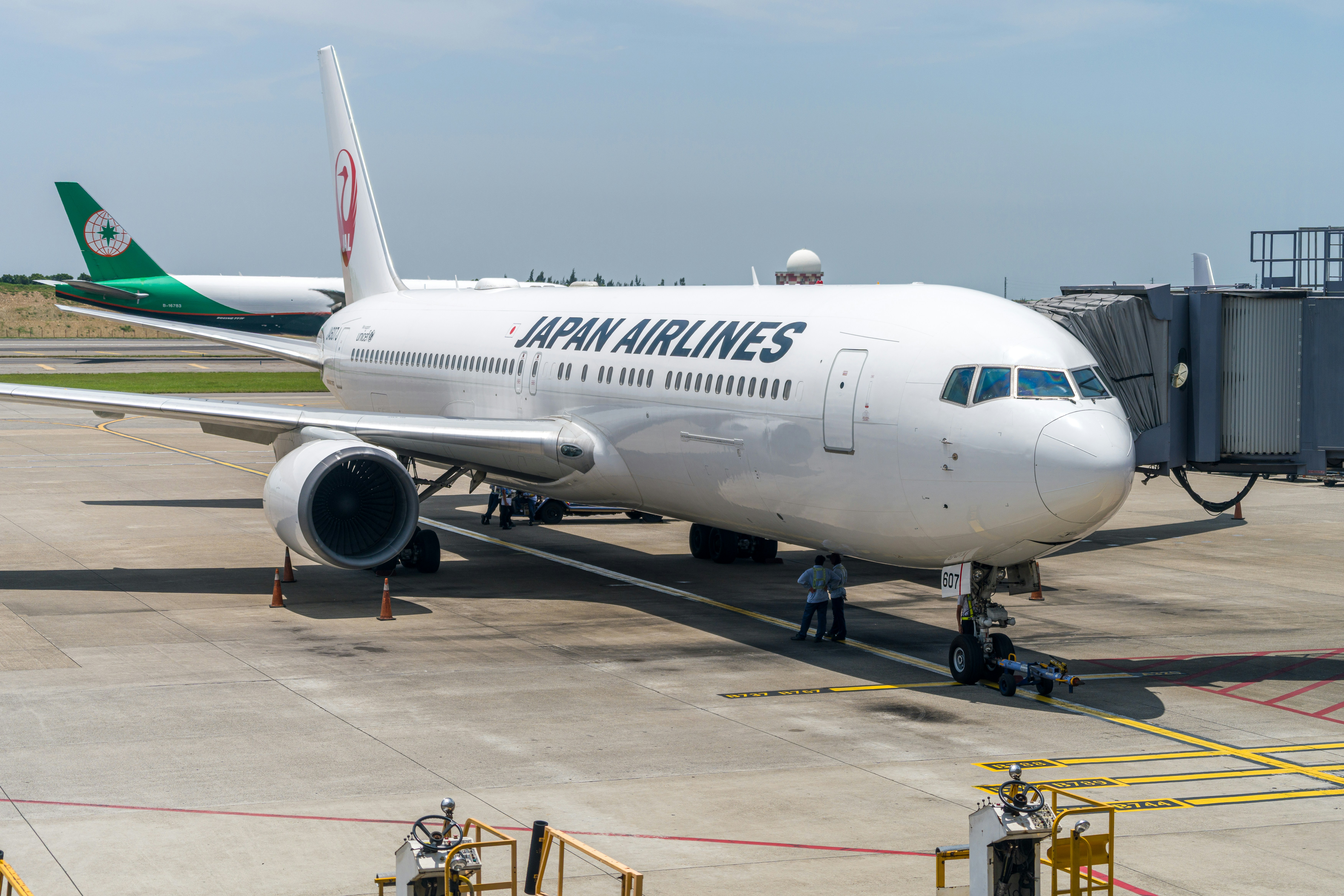 A japan airlines airplane parked at an airport gate.