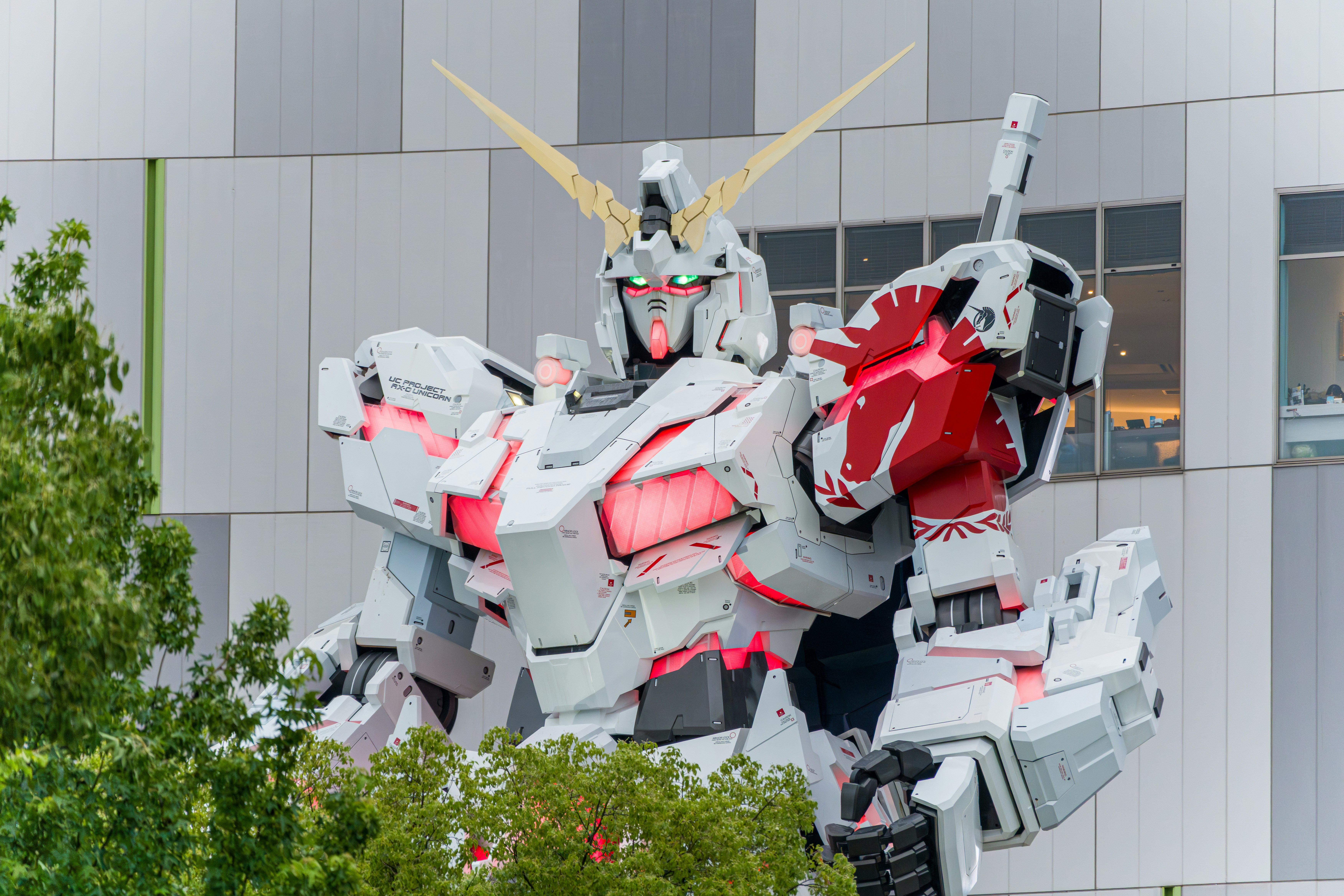 Large white robot statue with glowing red details.