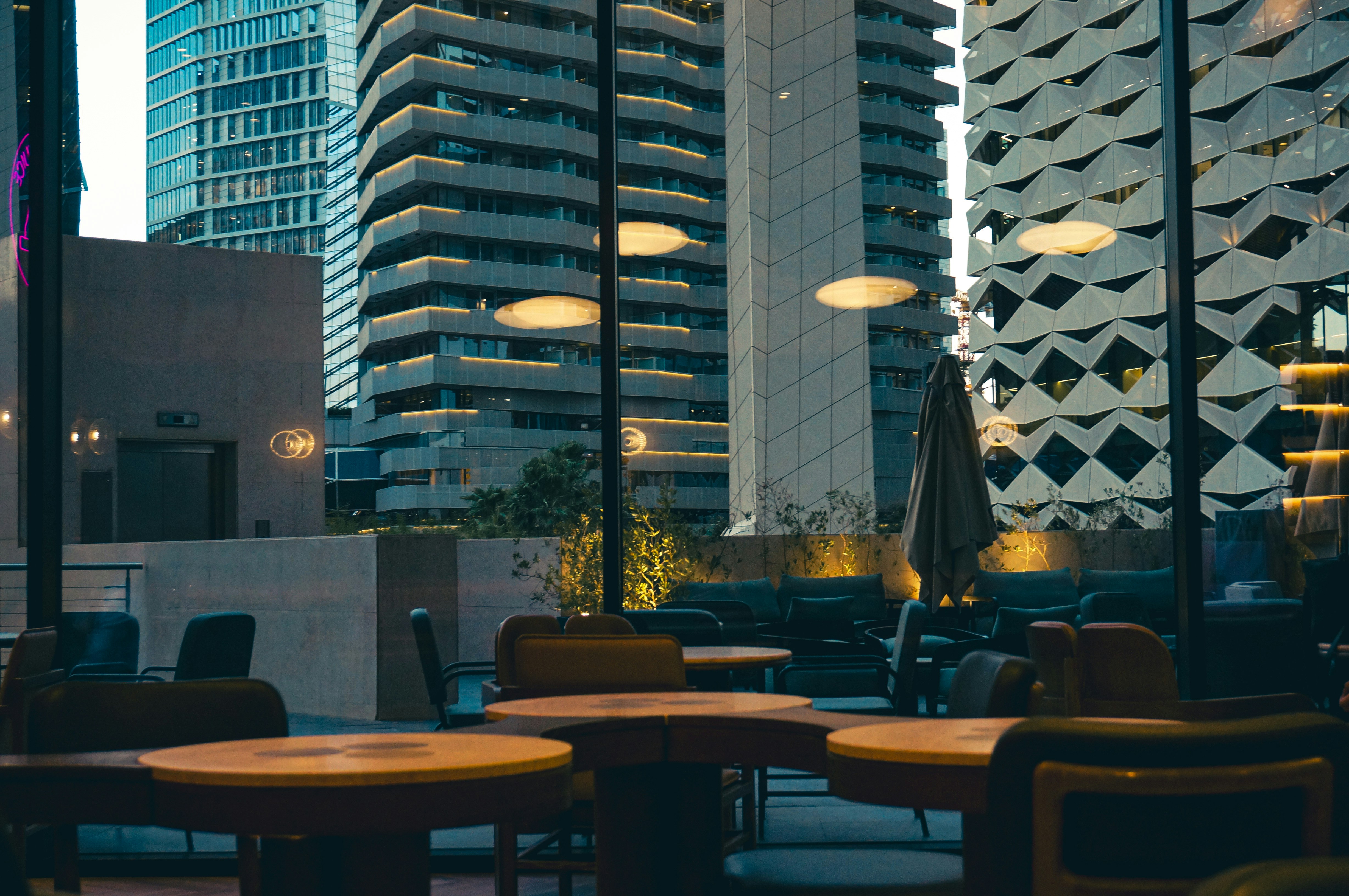 Cafe interior with city skyline view through windows.