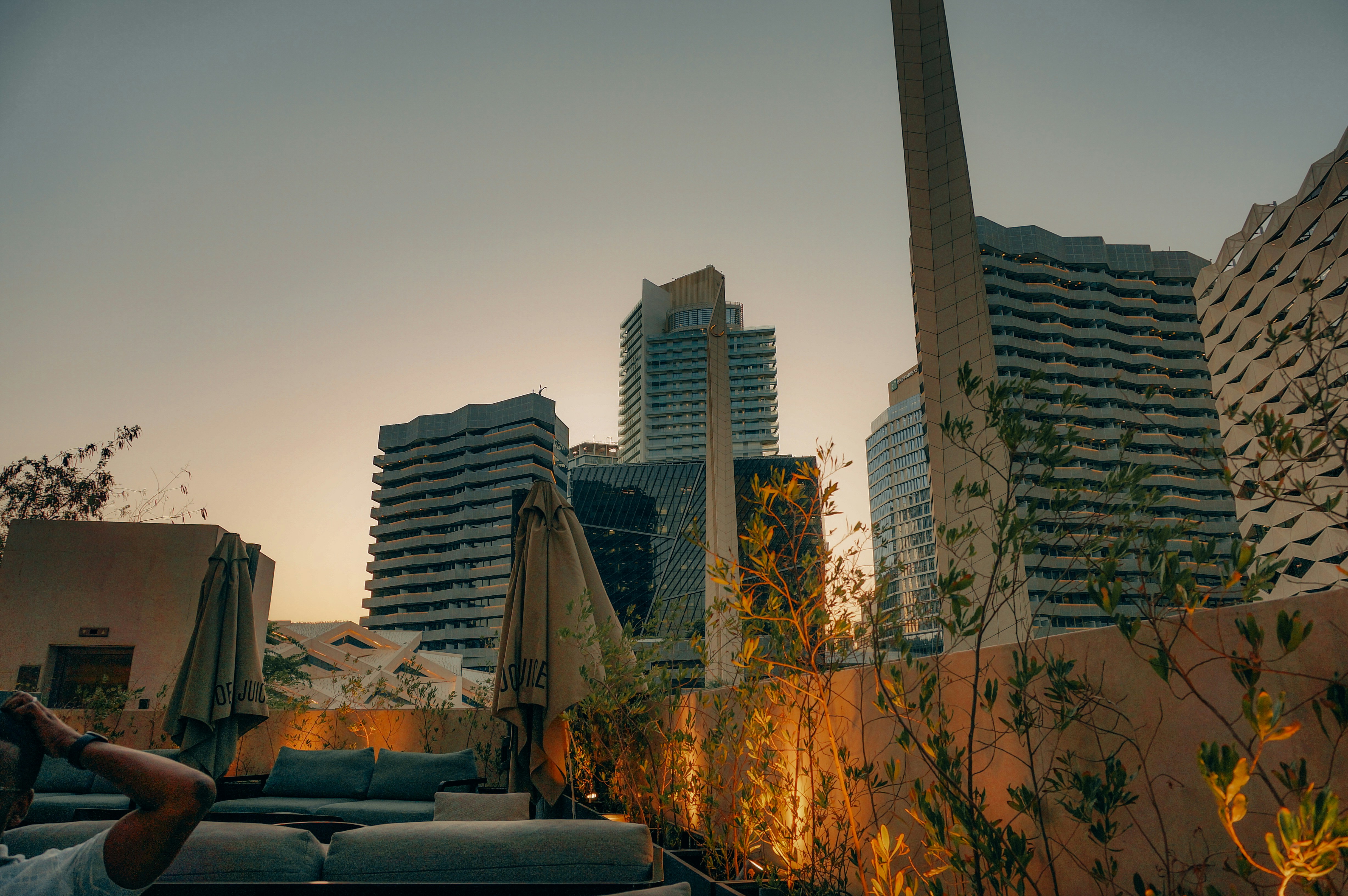 City skyline and rooftop lounge at sunset.