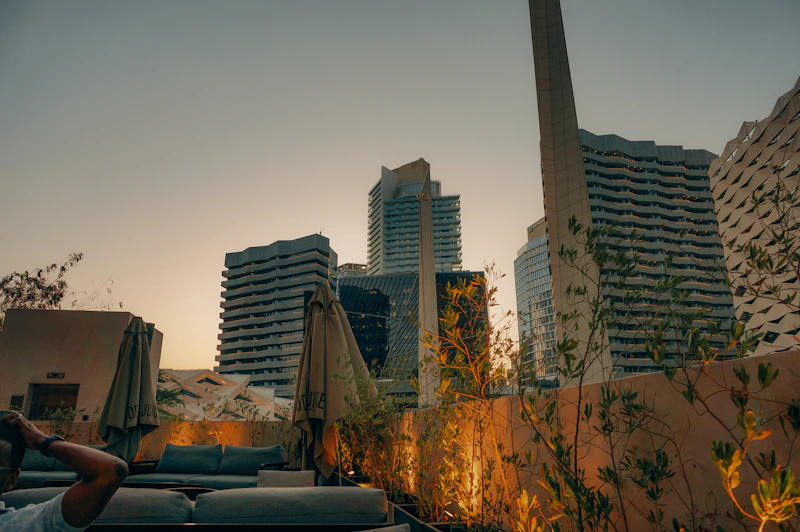 Lounge seating on a rooftop terrace overlooking a city skyline at dusk