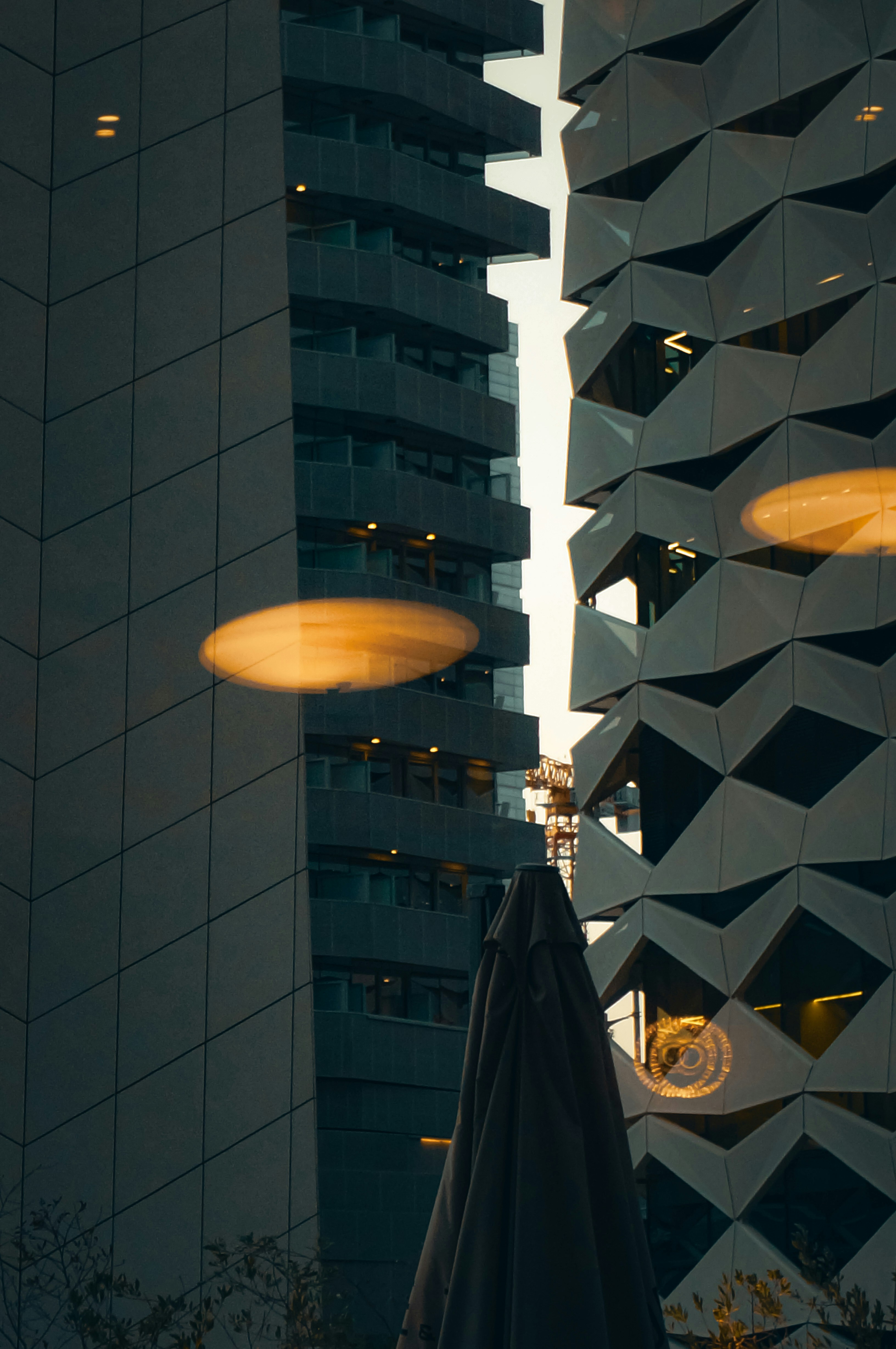 Modern buildings with geometric facades and orange light reflections.