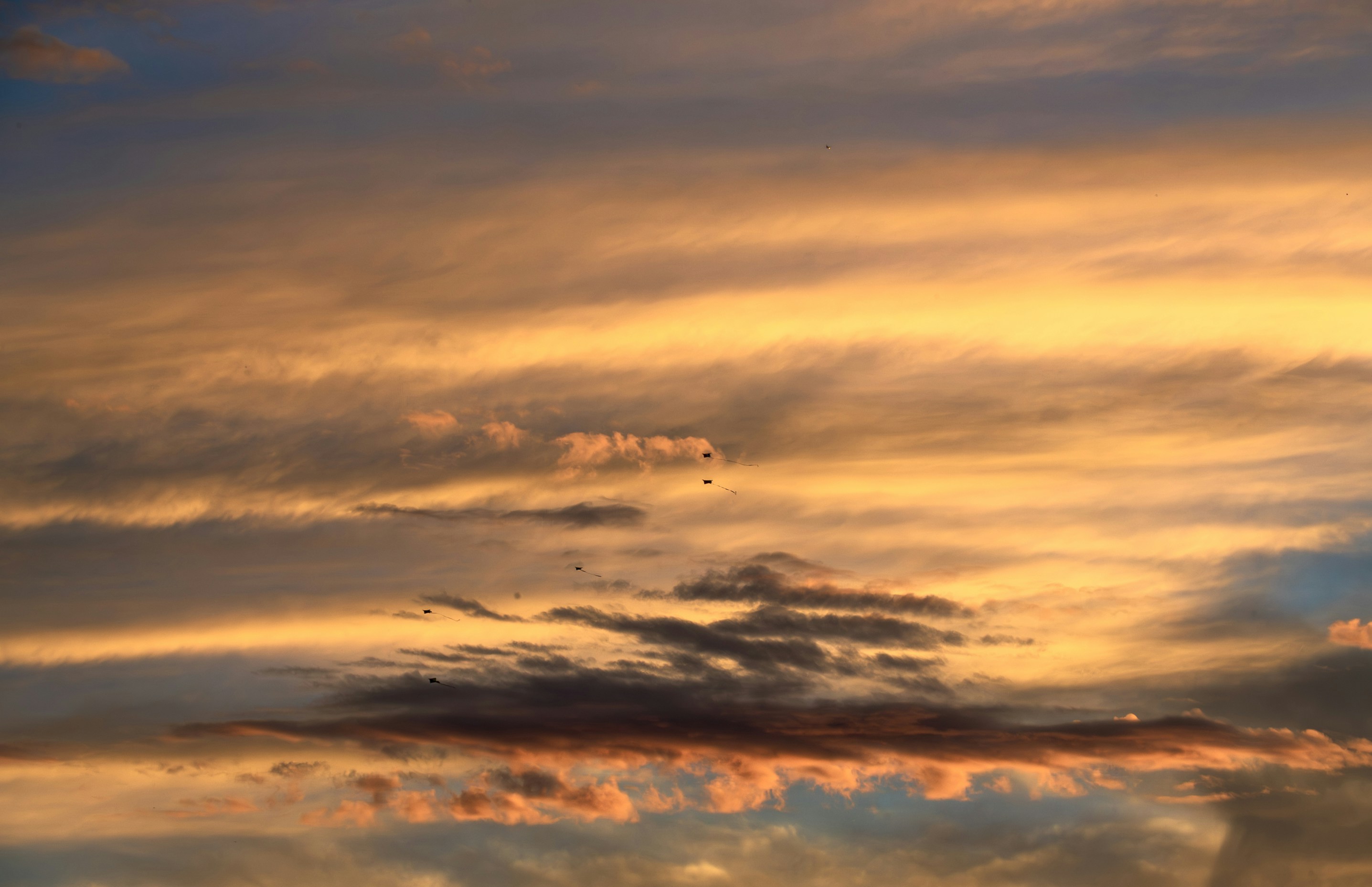 Vibrant orange and yellow clouds fill the sky at sunset
