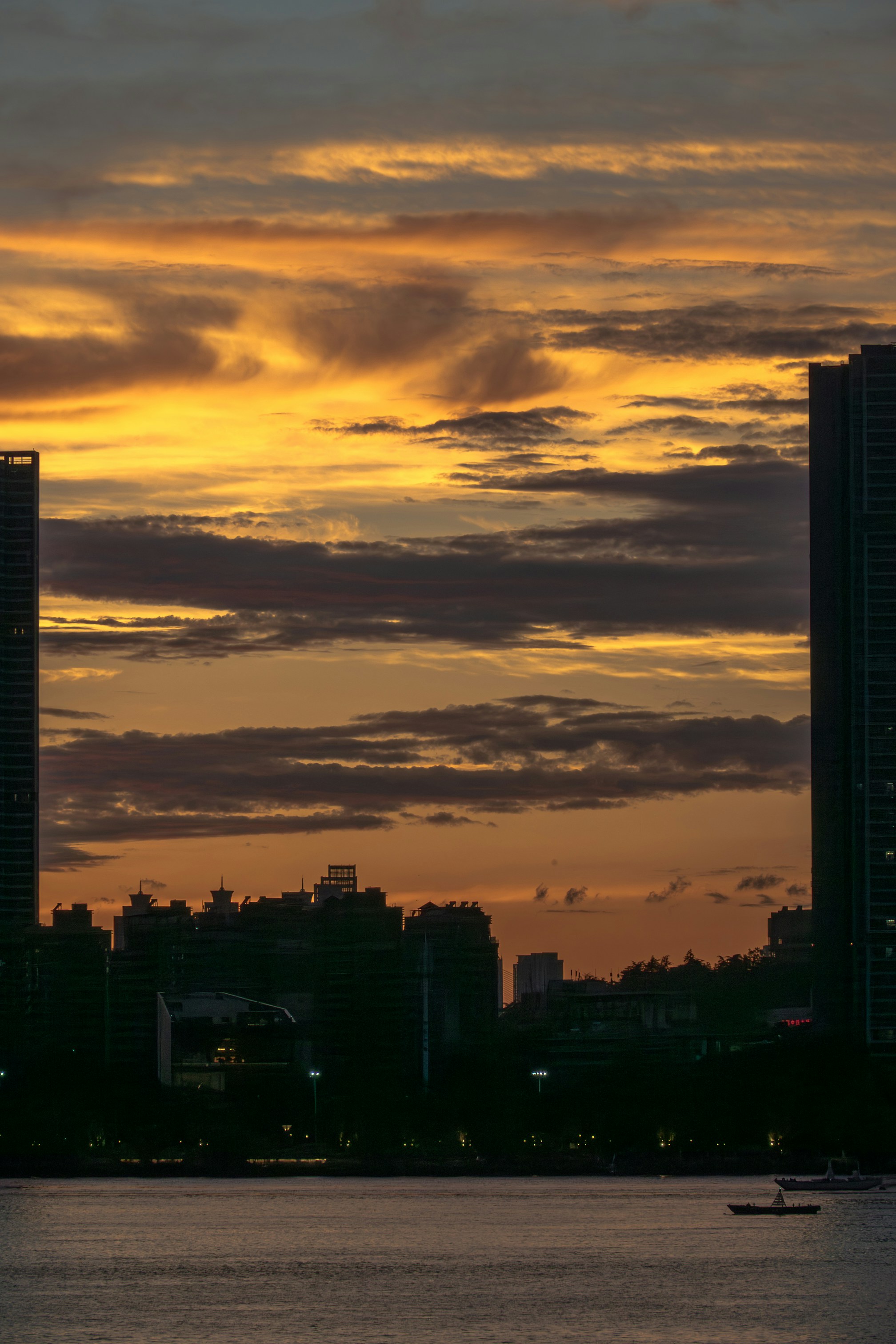 City skyline at sunset with vibrant sky and calm water