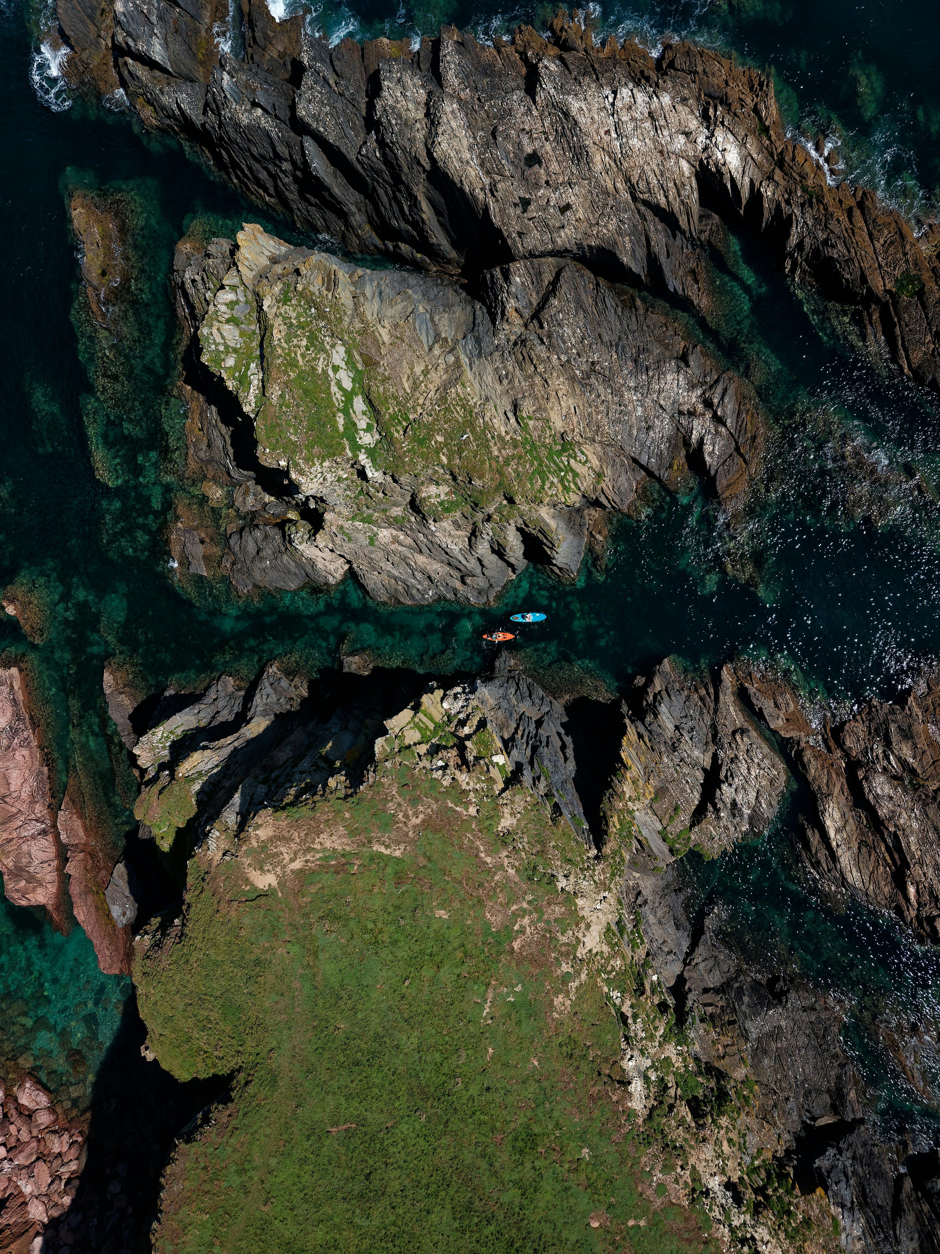 Paddleboarders navigating rocky gully at burgh island, devon