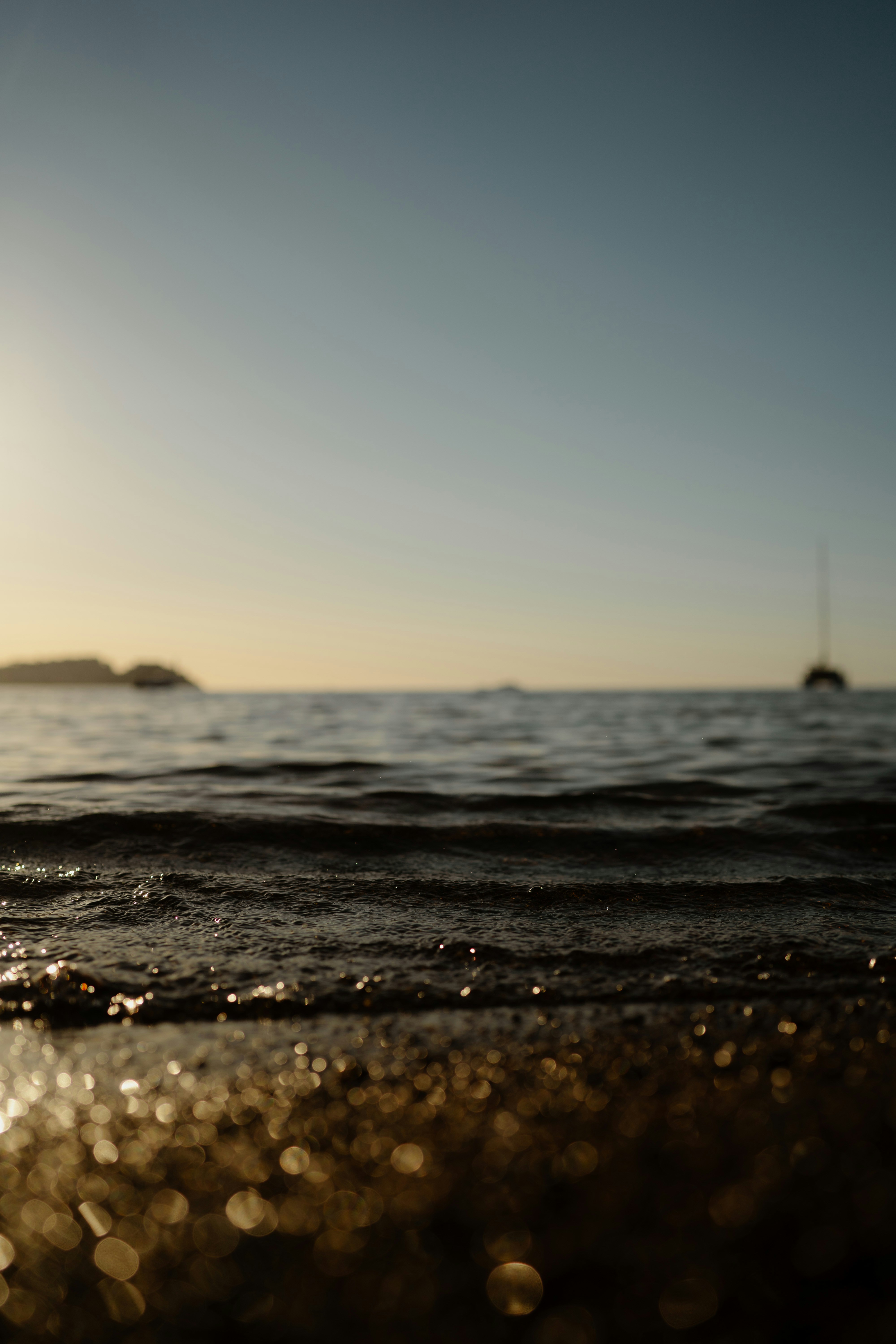 Ocean waves at sunset with distant boat