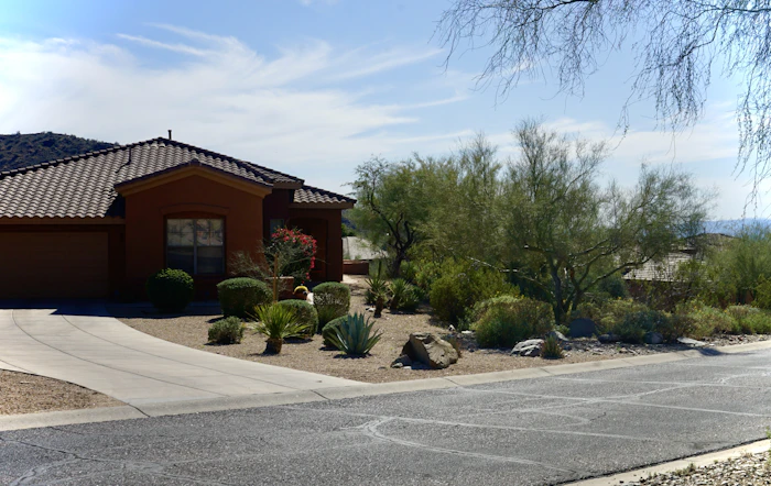 Home with desert landscaping and a wide driveway