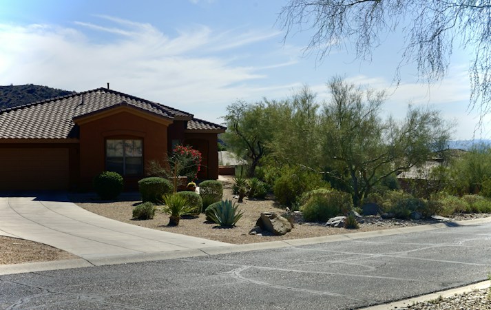 Clark County house with gravel desert landscaping and a wide driveway under clear sky